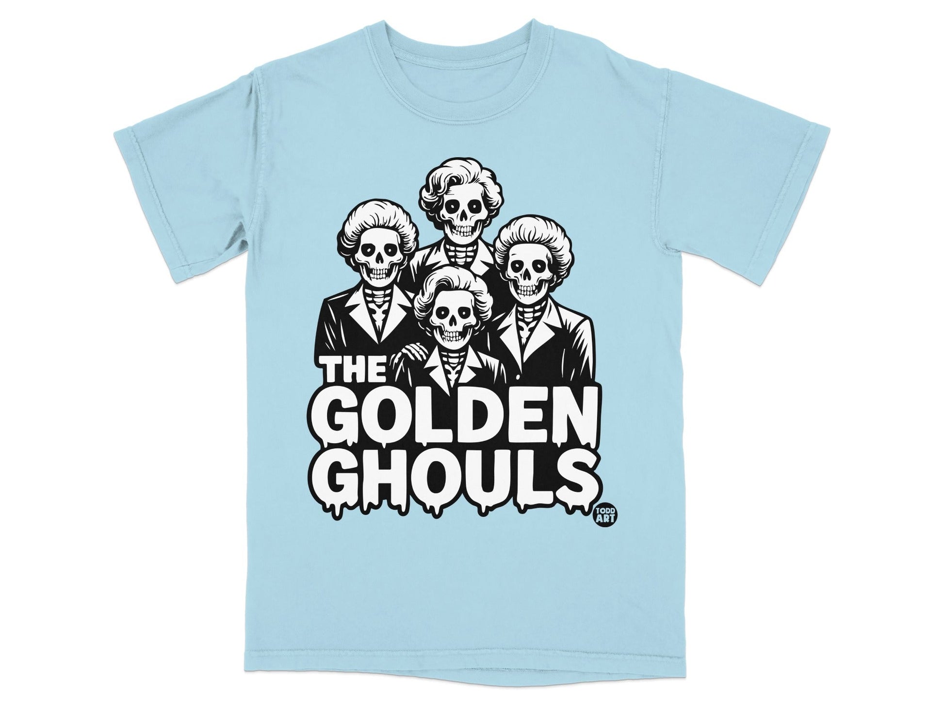 Light blue t-shirt featuring "The Golden Ghouls" with four skeleton heads wearing styled wigs.