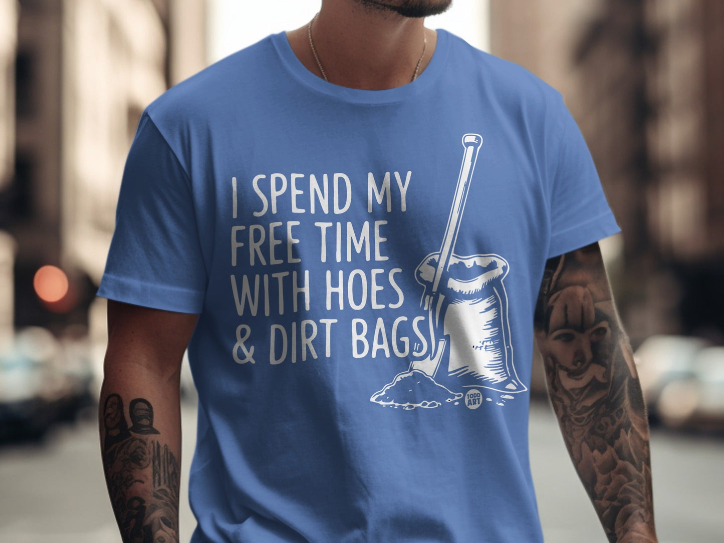 Blue t-shirt with white text and illustration of gardening tools.