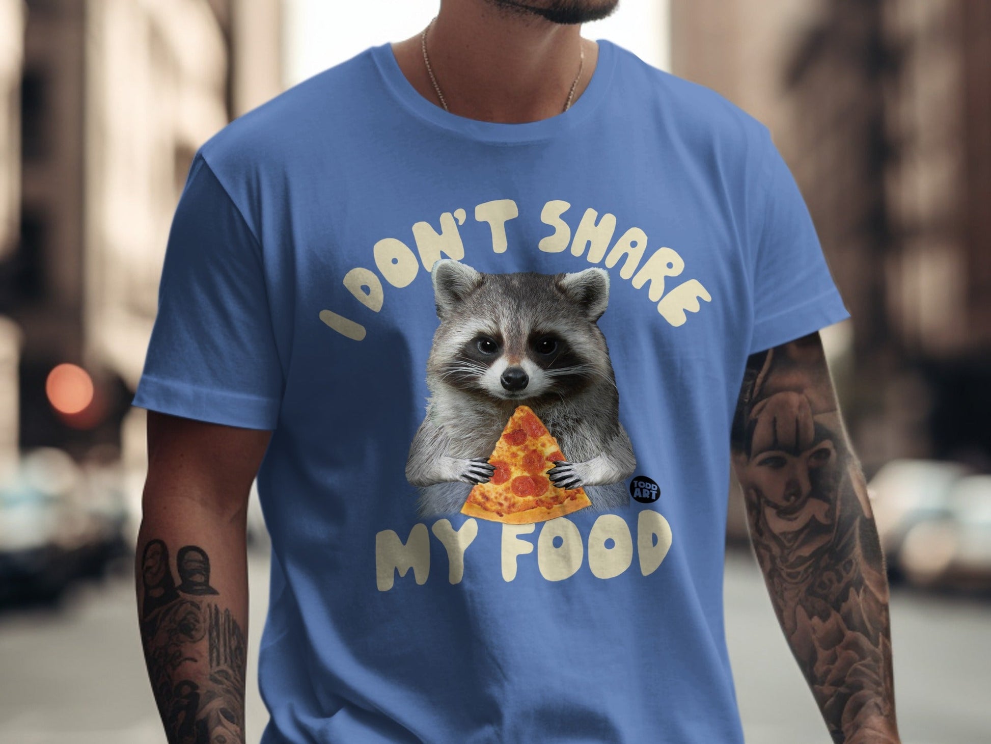 Raccoon wearing blue t-shirt holding a slice of pizza.
