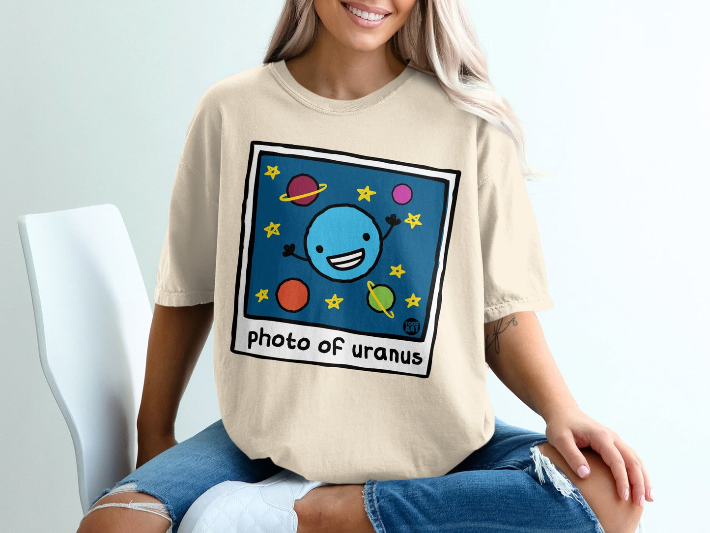 Cartoon drawing of smiling planet Uranus with stars and other planets, framed like a photo.