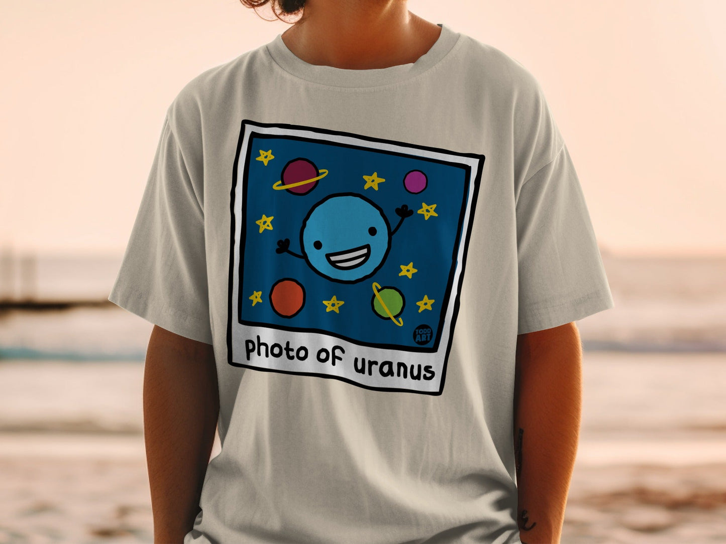 Gray t-shirt with a cartoon drawing of Uranus and stars.