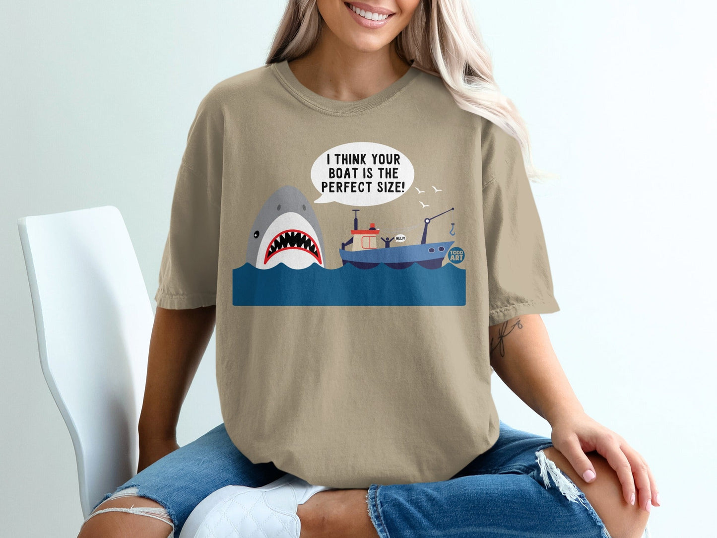 T-shirt with cartoon shark attacking a small boat with "HELP!" speech bubble.