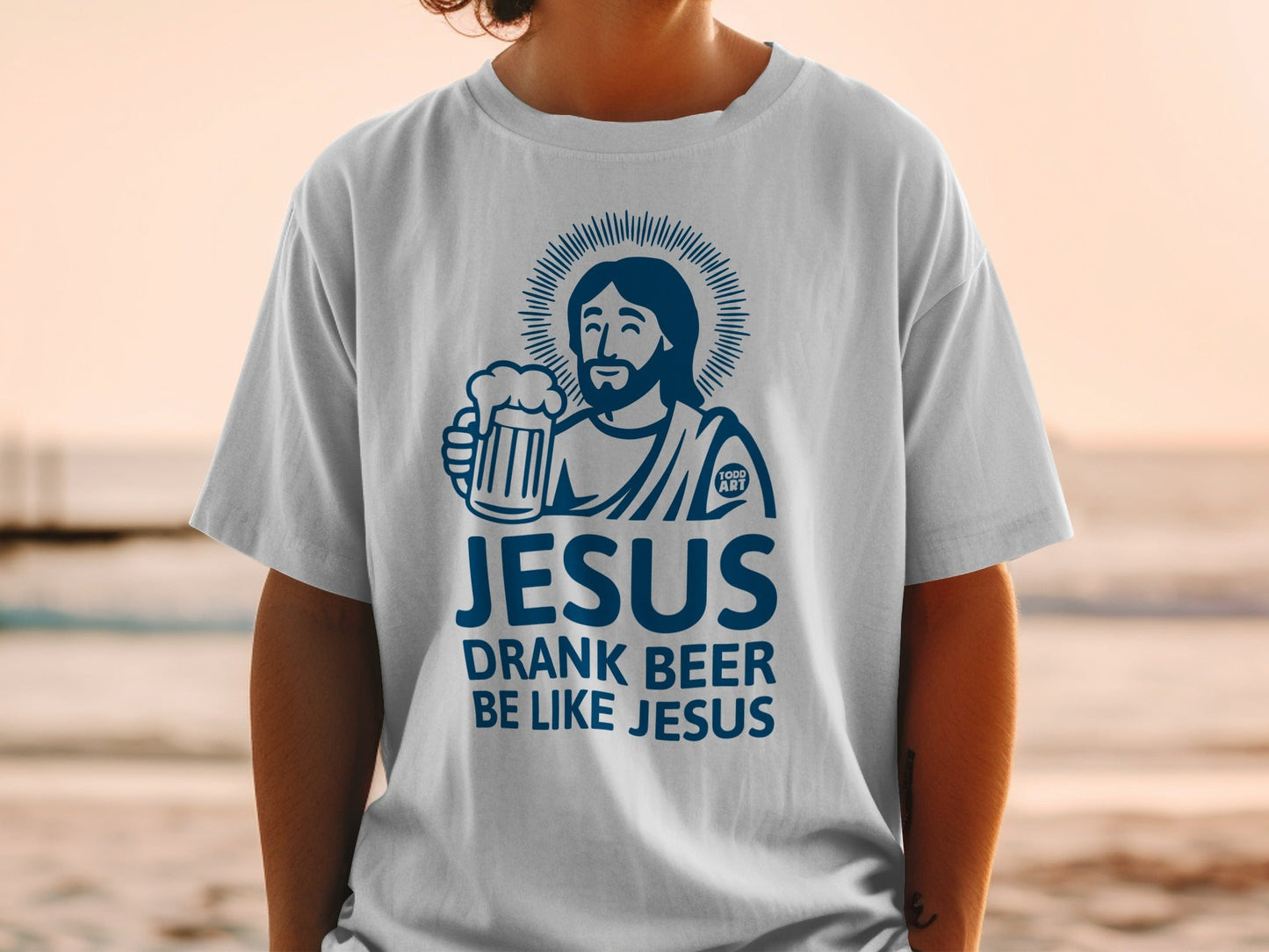 White t-shirt with blue graphic of Jesus holding a beer, text "JESUS DRANK BEER LIKE JESUS".