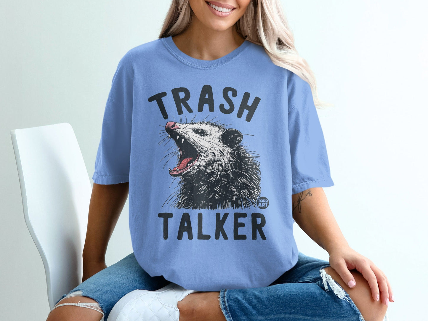 Blue t-shirt with "TRASH TALKER" text and a graphic of a possum.