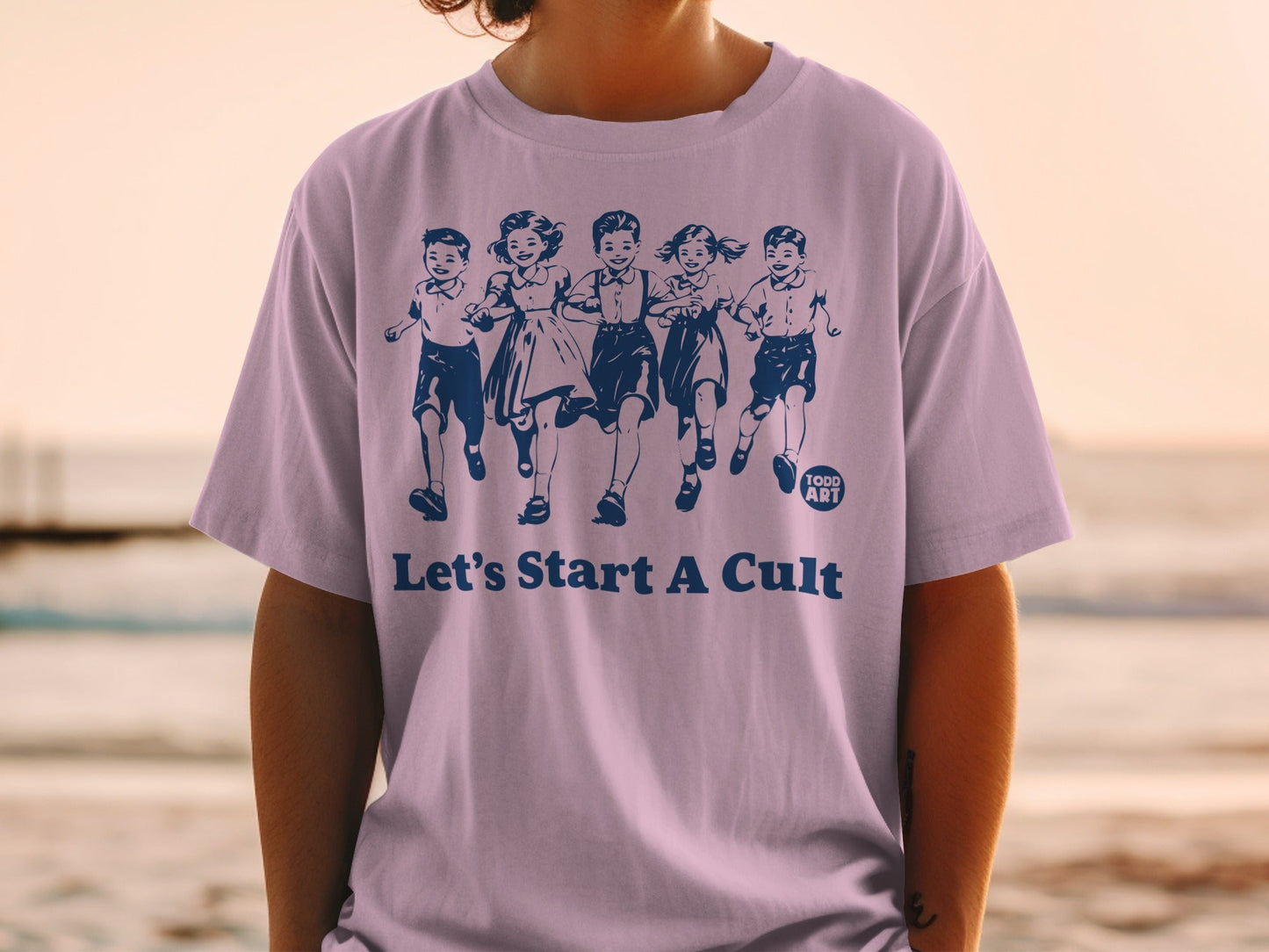 Purple t-shirt with navy print of children running and "Let's Start A Cult".