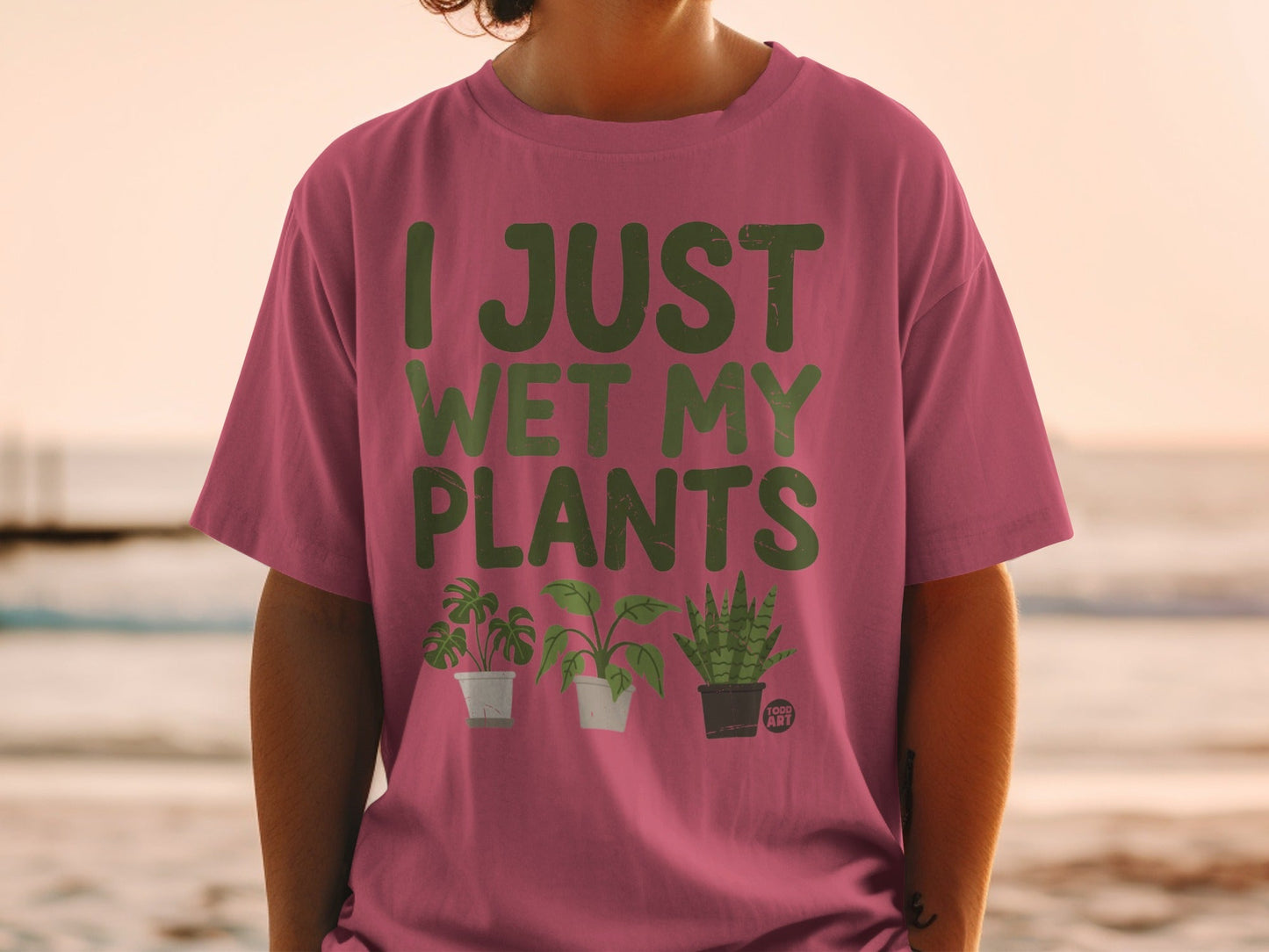 Pink t-shirt with "I JUST WET MY PLANTS" and three cartoon plants.