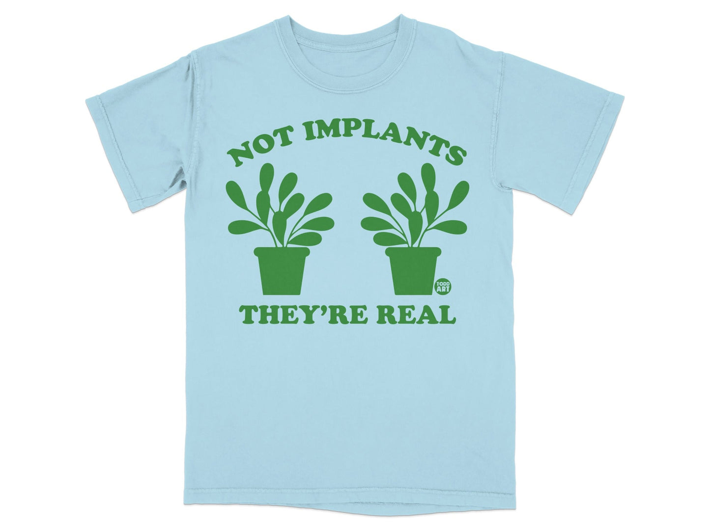 Light blue t-shirt with green text and potted plants reading "NOT IMPLANTS THEY'RE REAL".