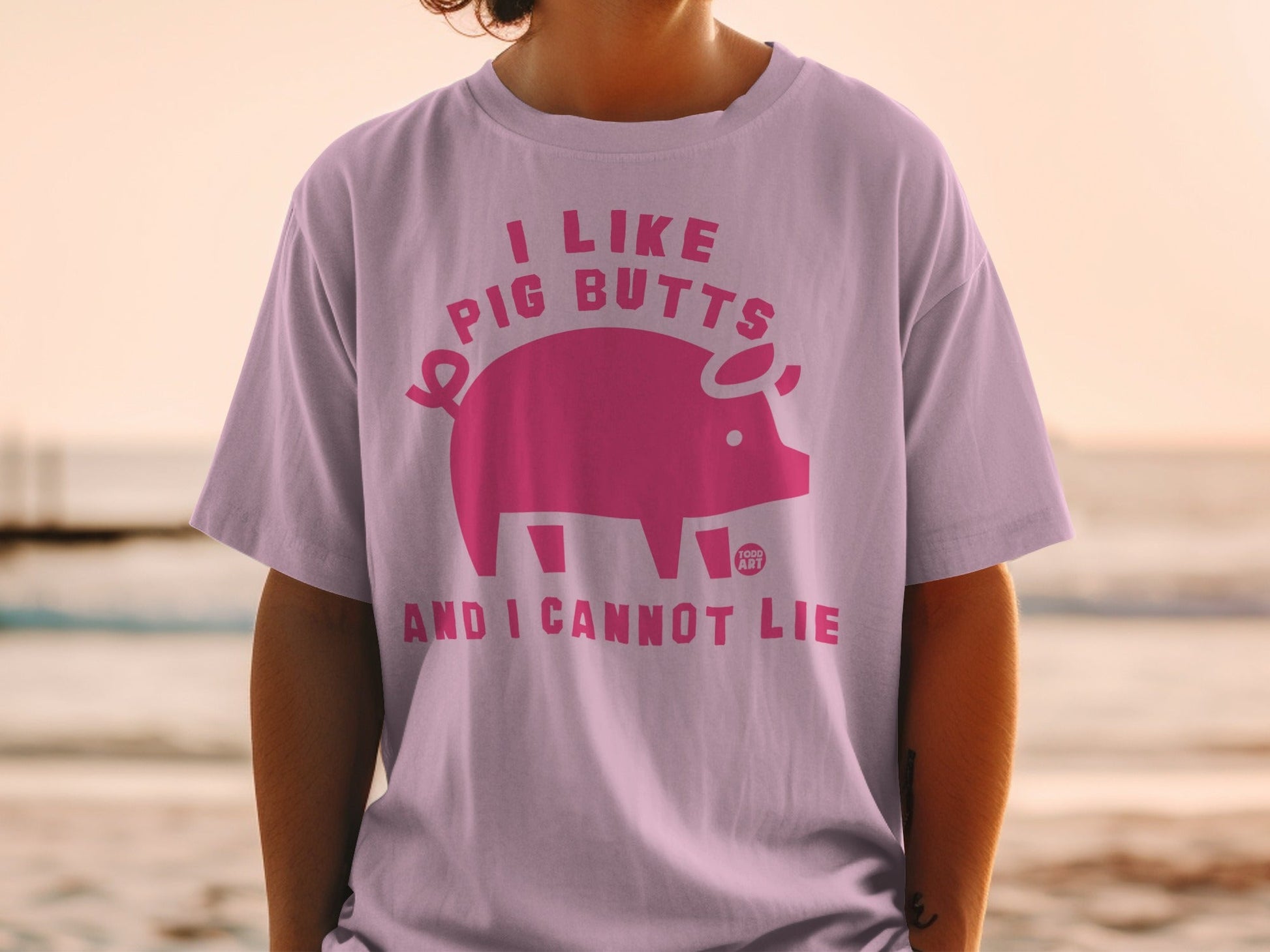 Pink t-shirt with pig graphic and text "I like pig butts and I cannot lie".