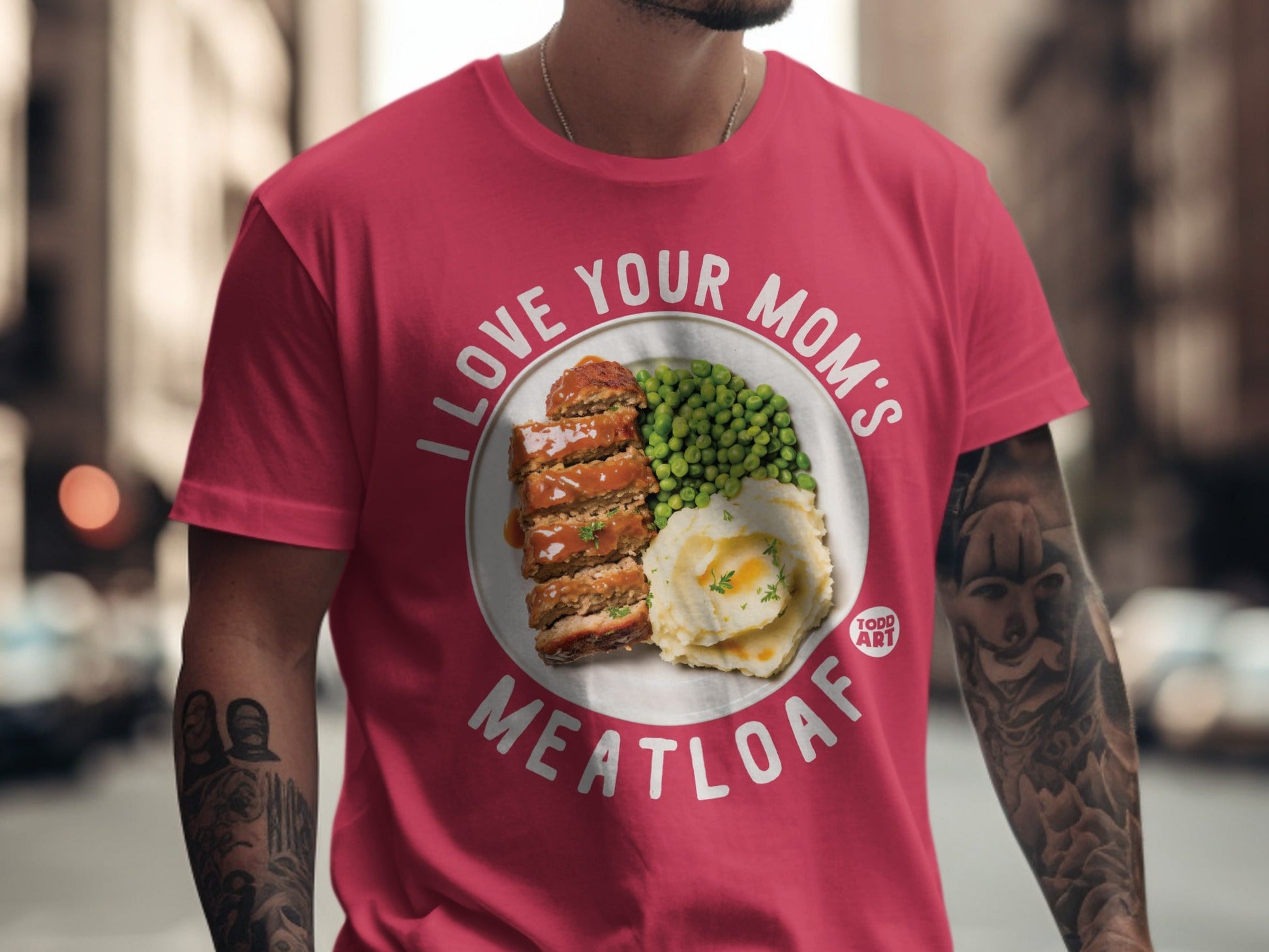 Pink t-shirt with "I love your mom's meatloaf" and a plate of meatloaf and peas.