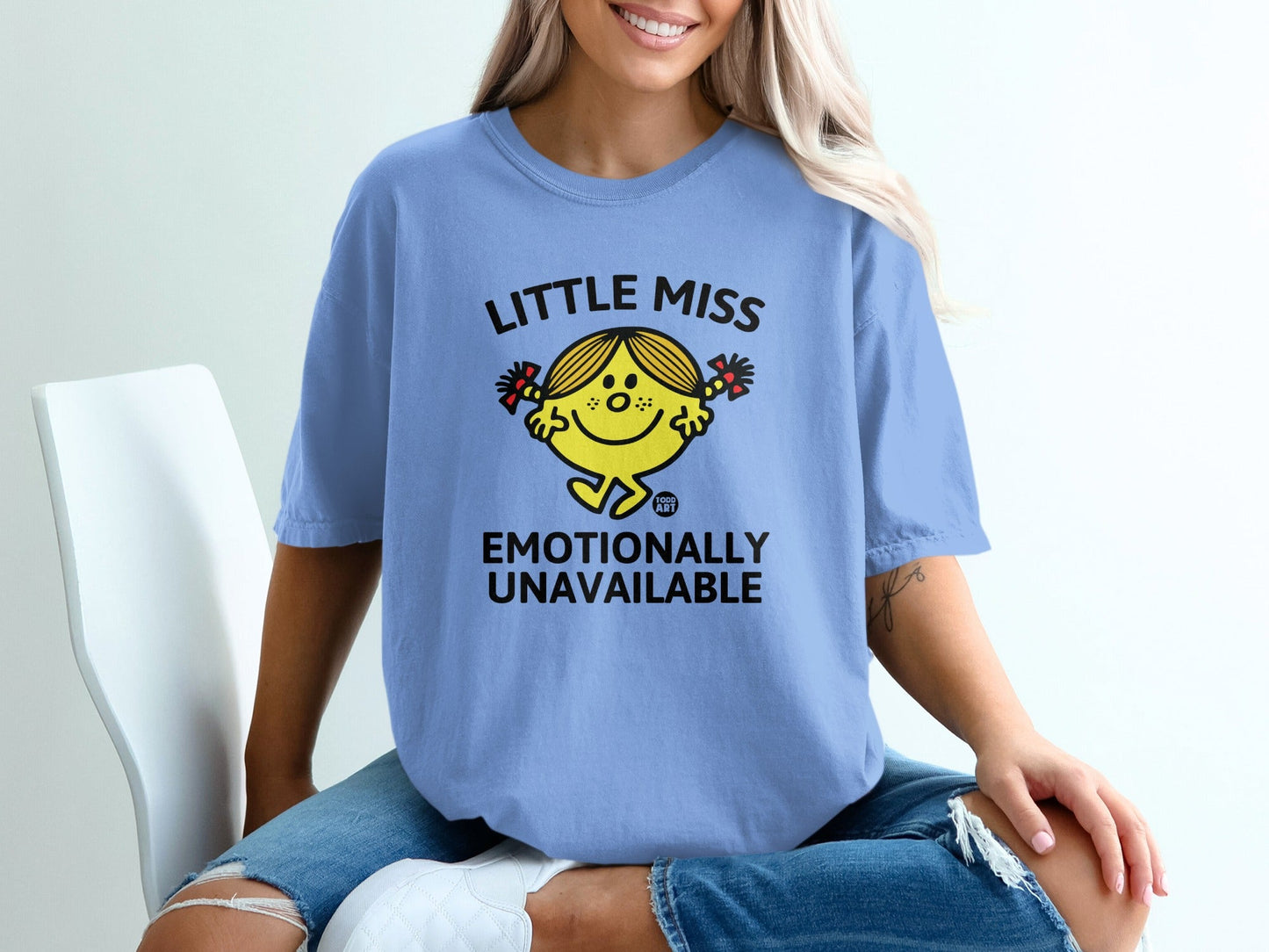 Blue t-shirt with "Little Miss Emotionally Unavailable" text and a cartoon character.