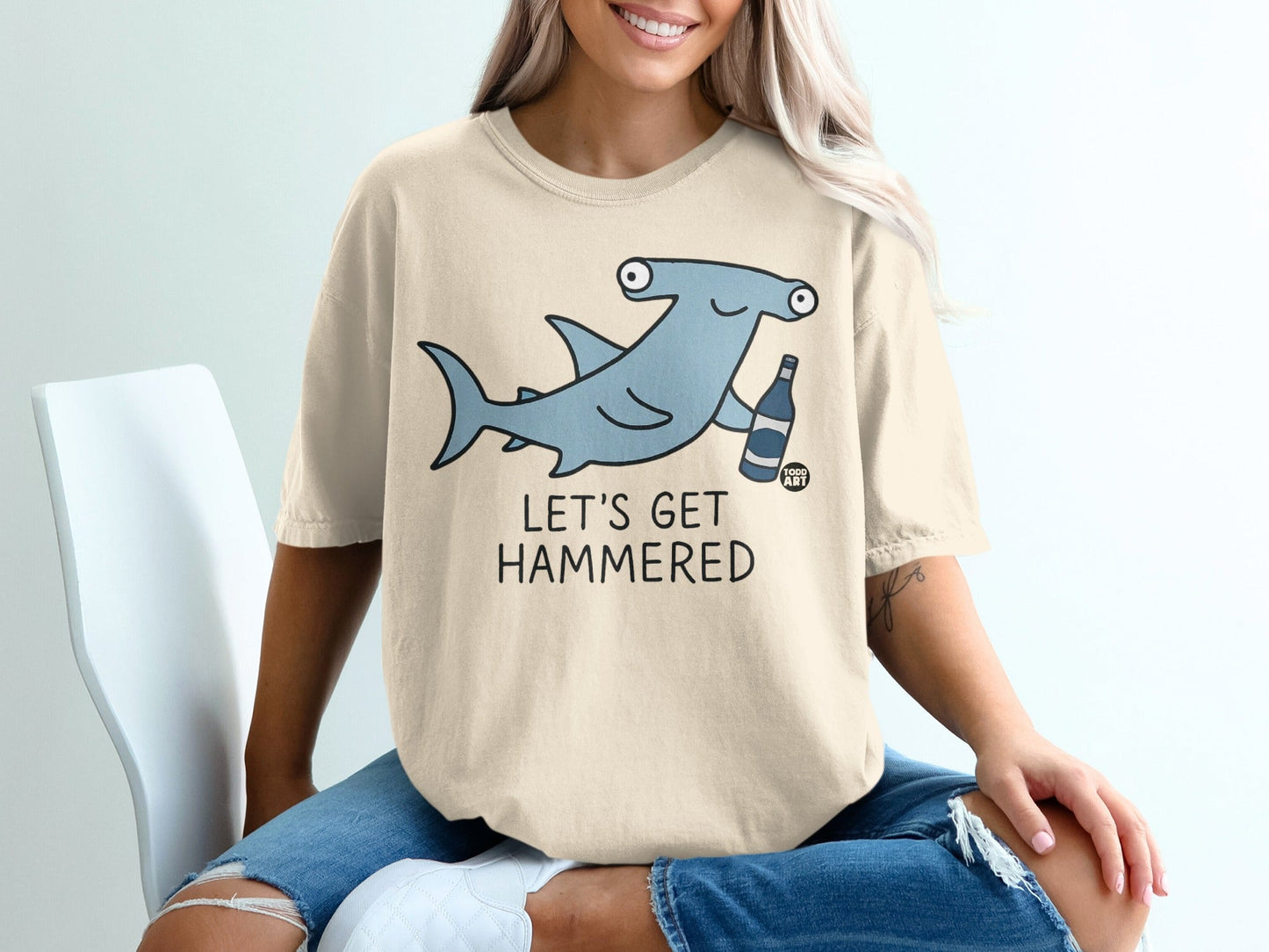 Hammerhead shark wearing sunglasses and holding a drink, text "LET'S GET HAMMERED".