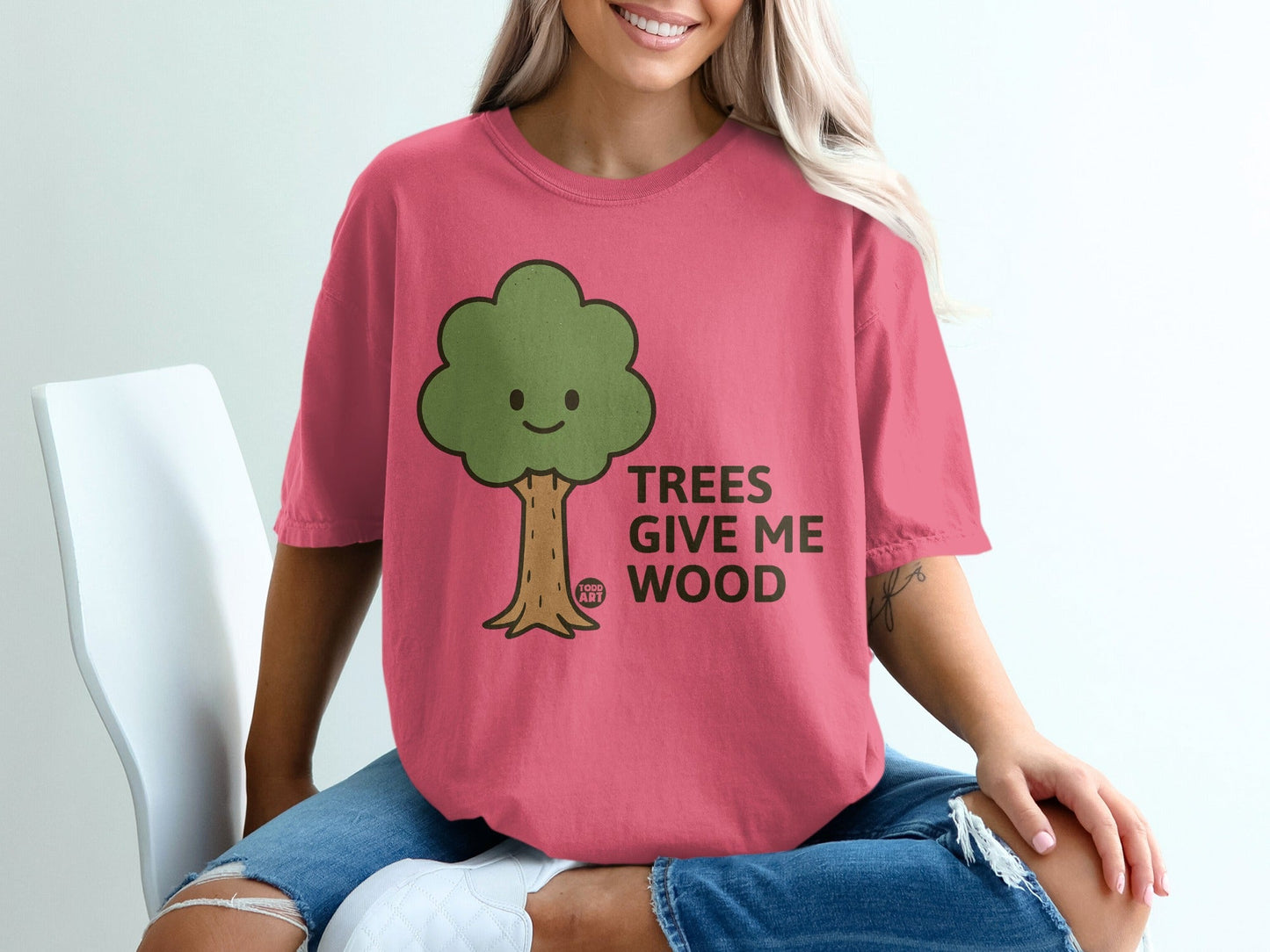 Pink t-shirt with cartoon tree and text "TREES GIVE ME WOOD".