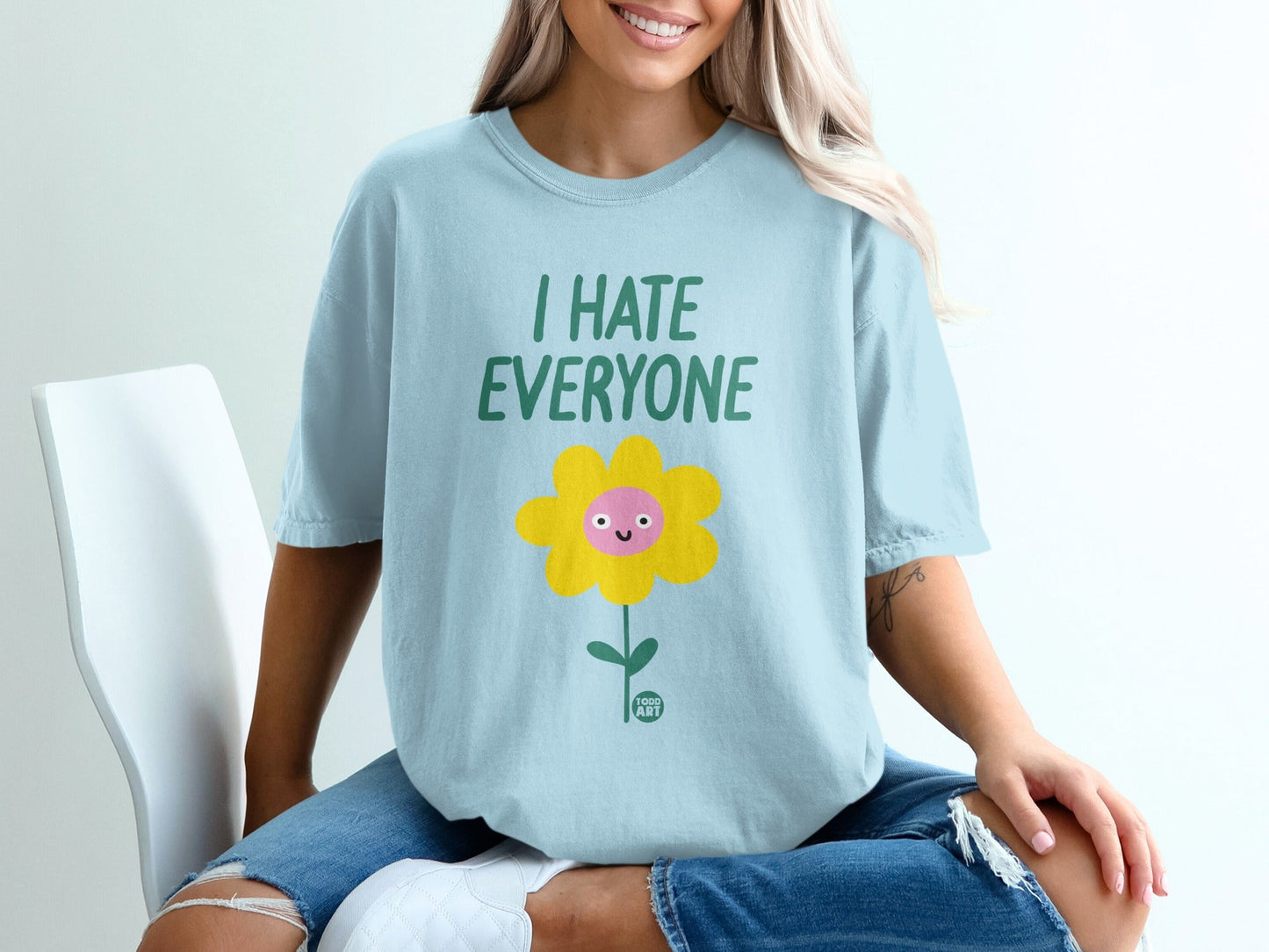 Light blue t-shirt with a smiling cartoon flower and "I HATE EVERYONE" text.