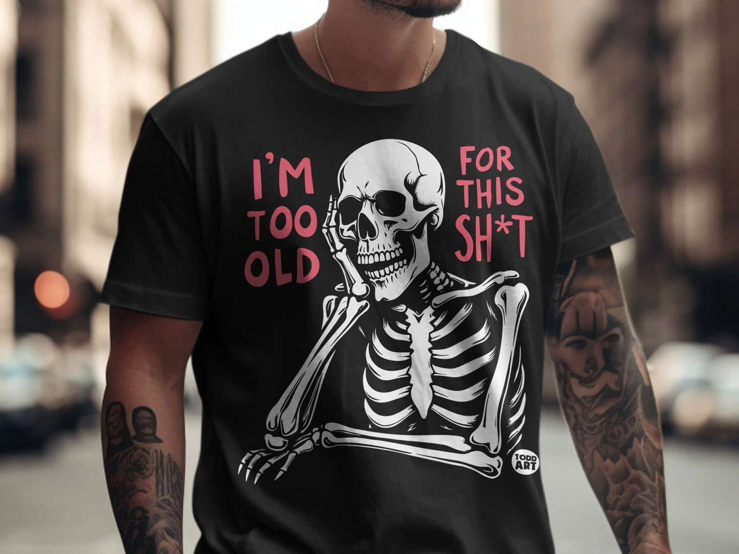 Black t-shirt with pink text "I'm TOO OLD FOR THIS SH*T" and a skeleton graphic.