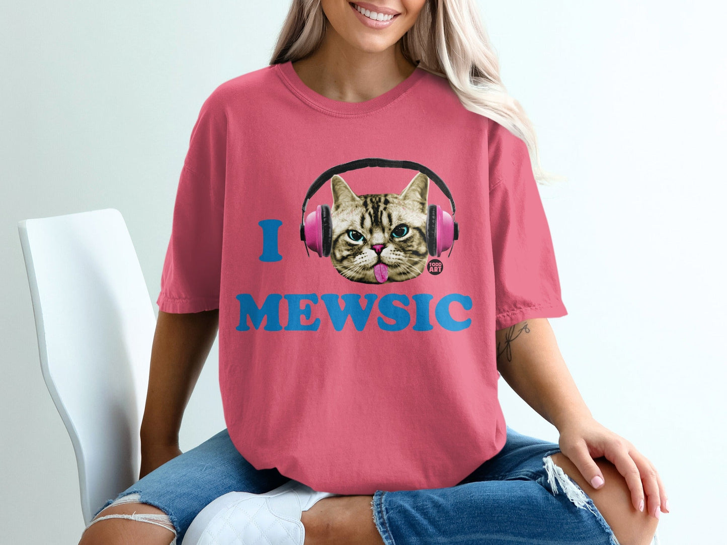Pink t-shirt with "I MEWSIC" text and a cat wearing headphones.