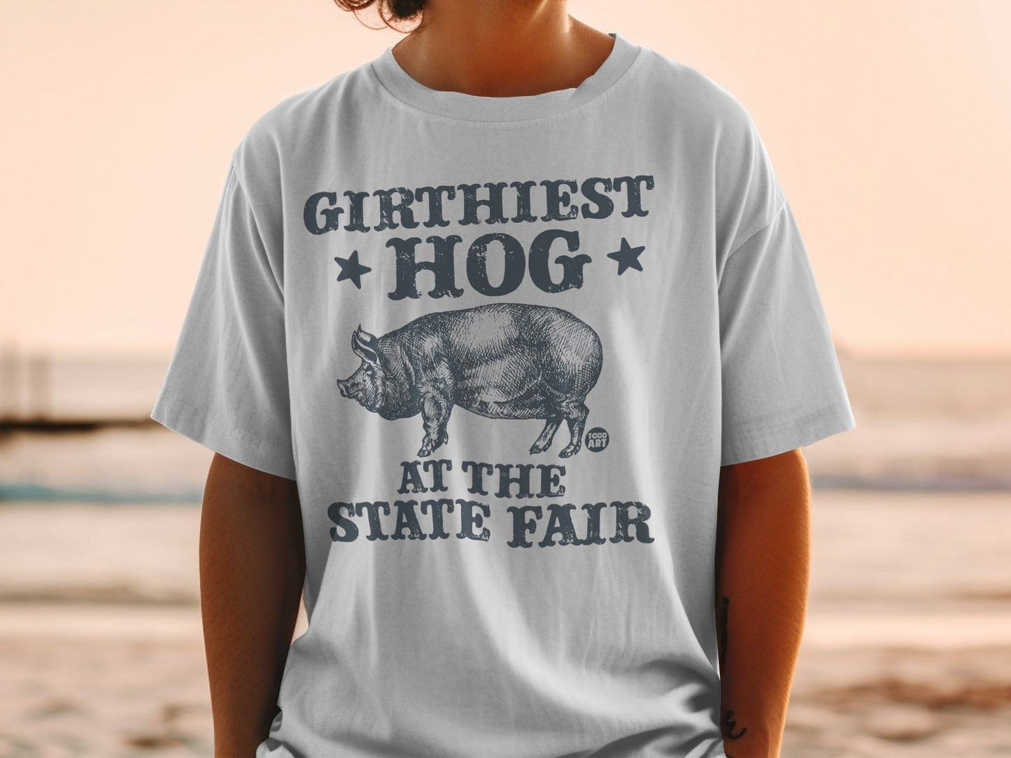 T-shirt with "GIRTHIEST HOG AT THE STATE FAIR" text and pig graphic.