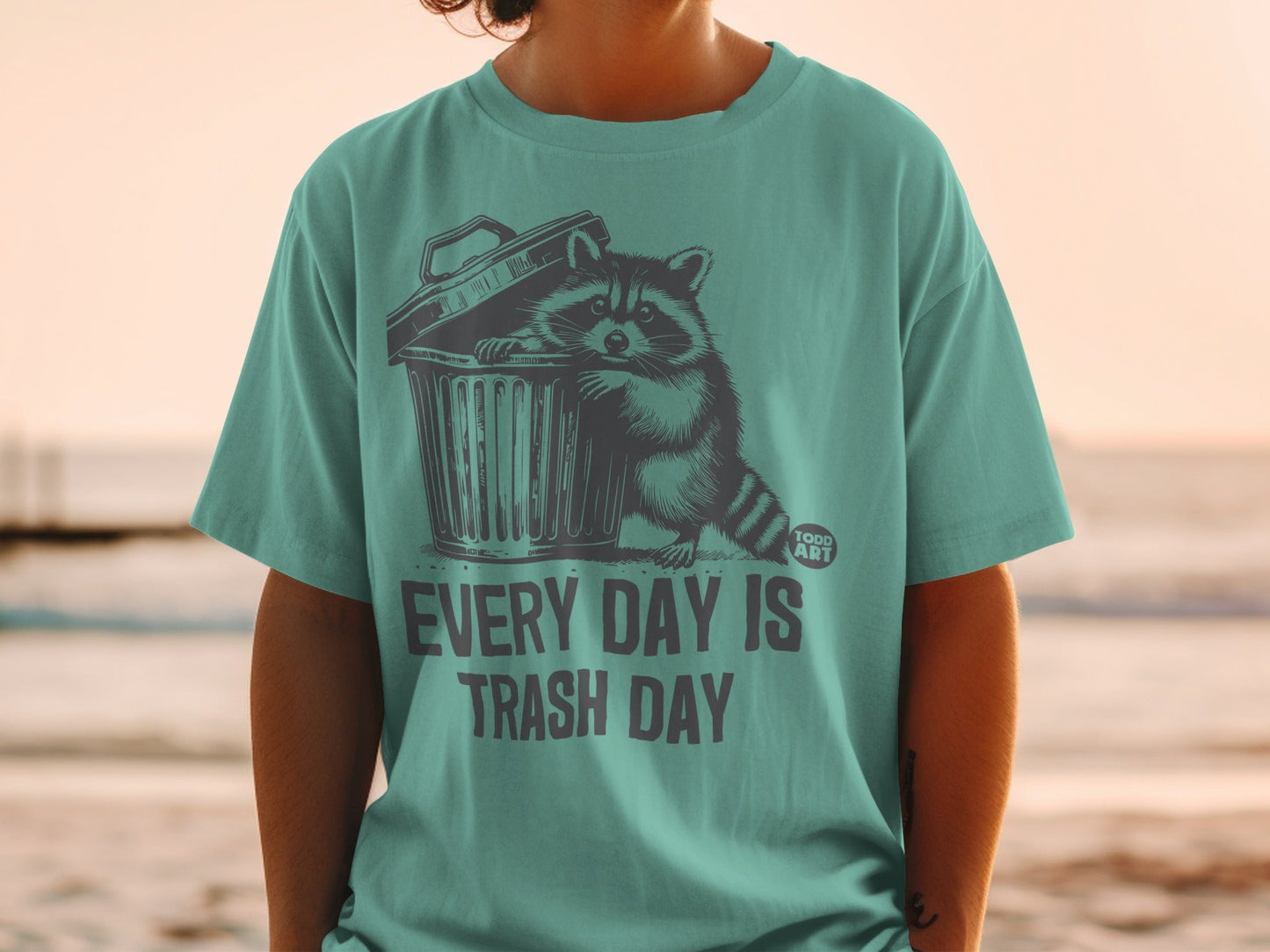 T-shirt with raccoon in trash can graphic and "Every Day Is Trash Day" text.