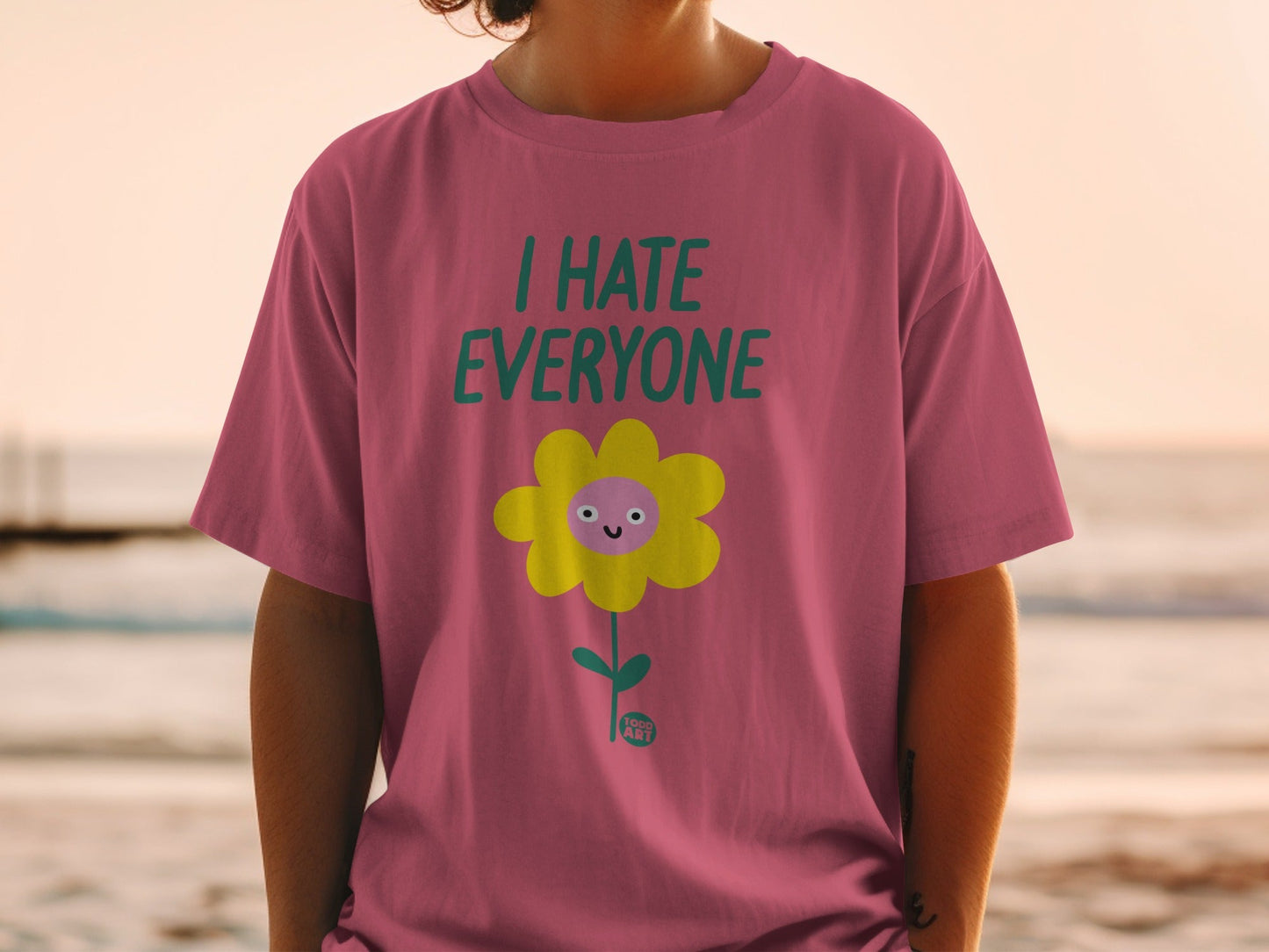 Pink t-shirt with cartoon flower saying "I HATE EVERYONE".