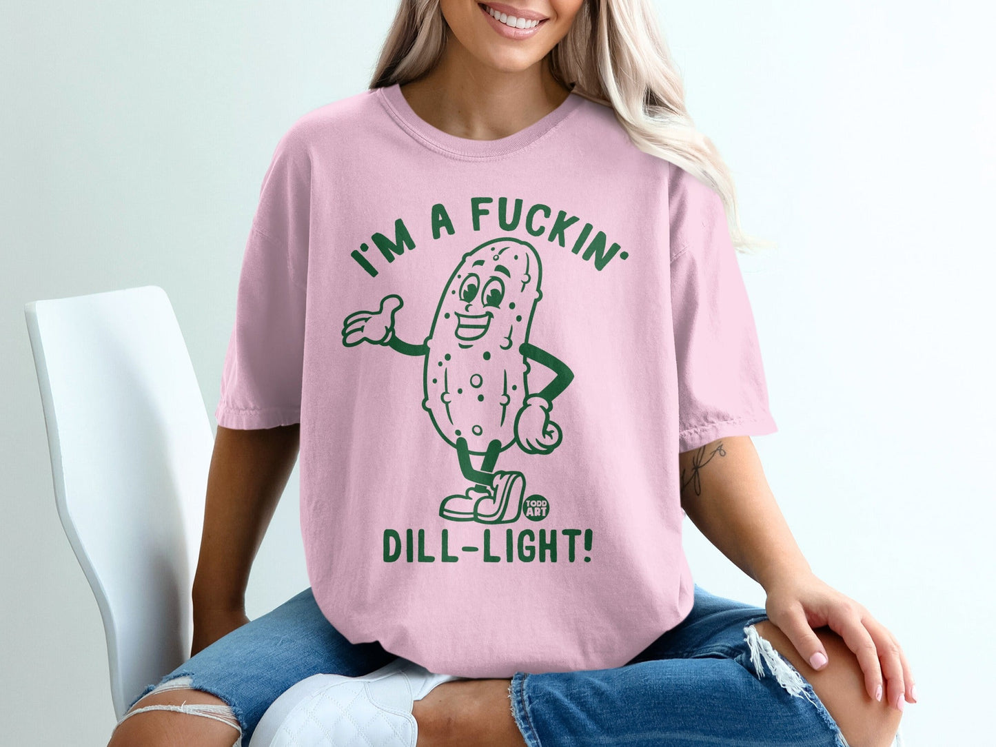 Pink t-shirt with cartoon pickle saying "I'm a fuckin' dill-light!".