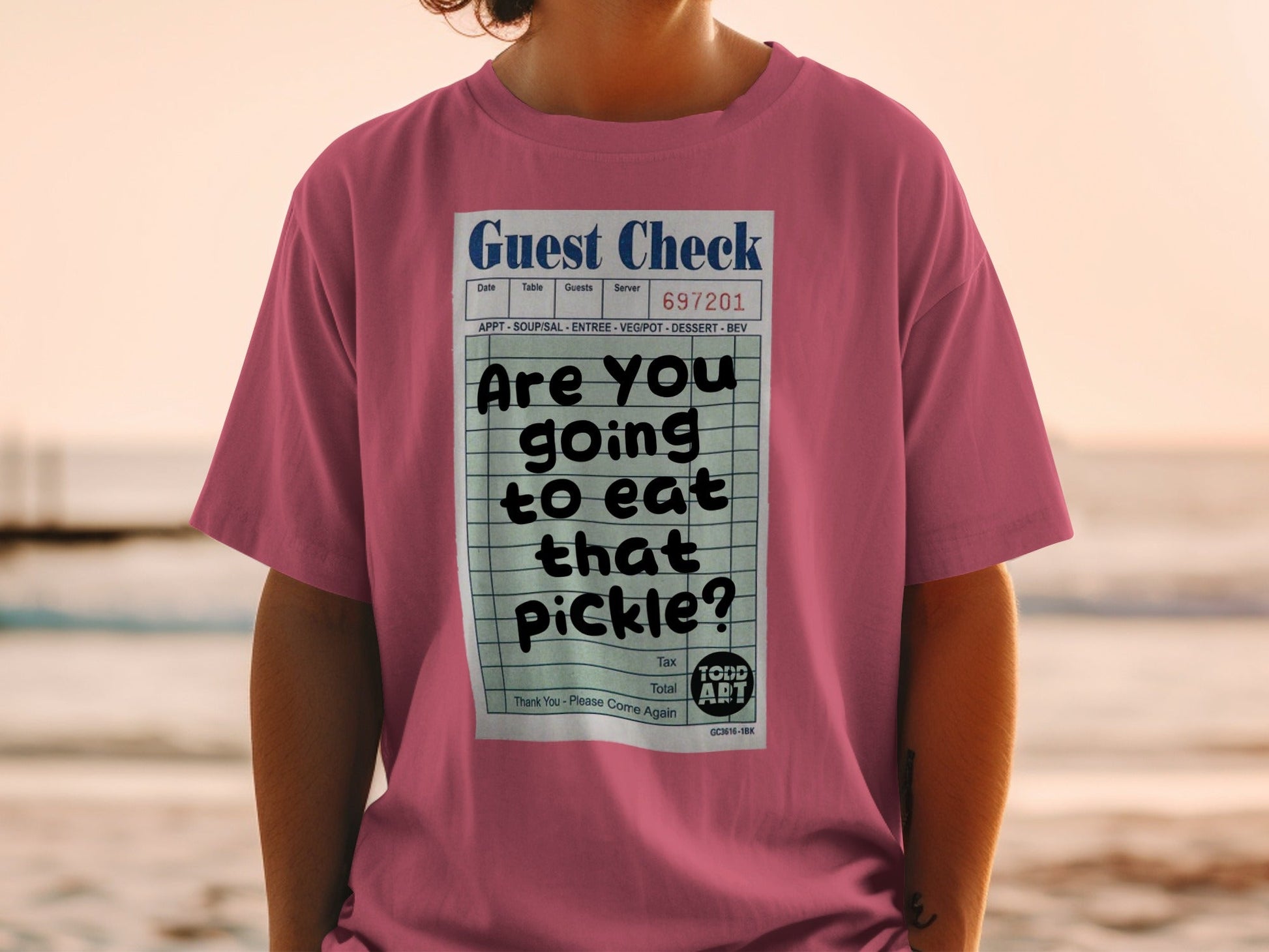 Pink t-shirt with a guest check graphic asking "Are you going to eat that pickle?"