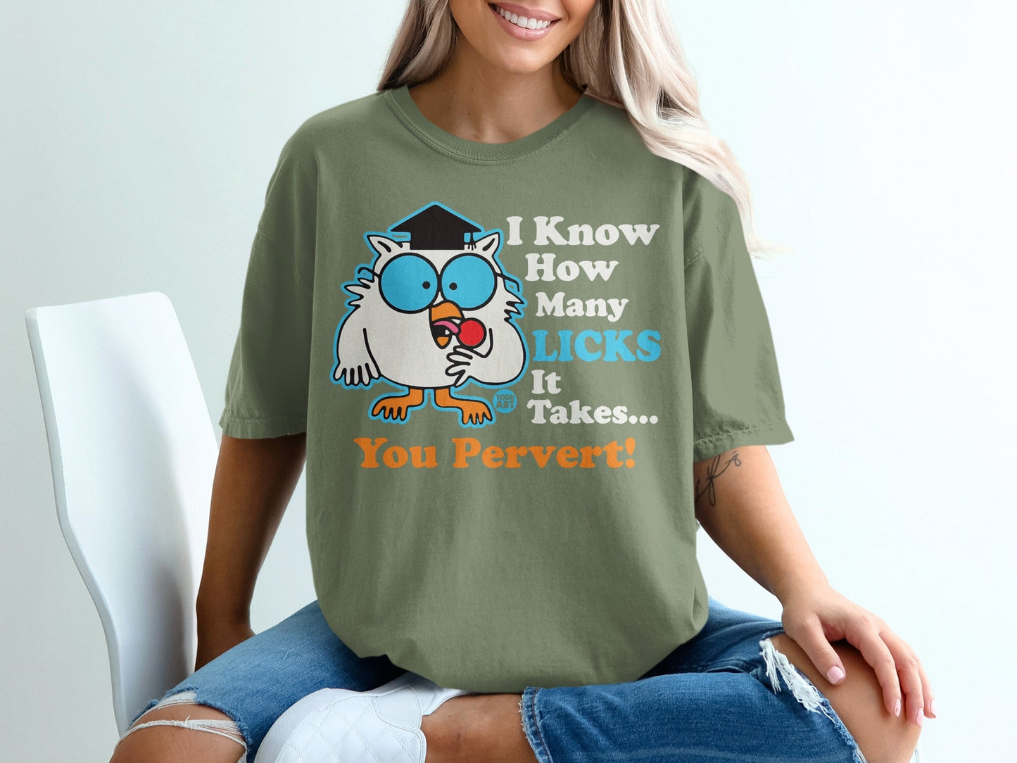 Green t-shirt with an owl wearing a graduation cap, holding a lollipop.
