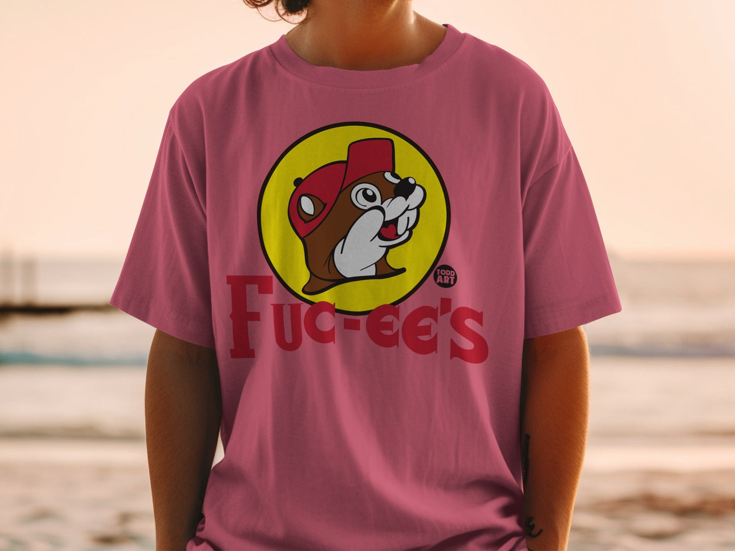 Bucee's beaver mascot in a red hat on a pink t-shirt.