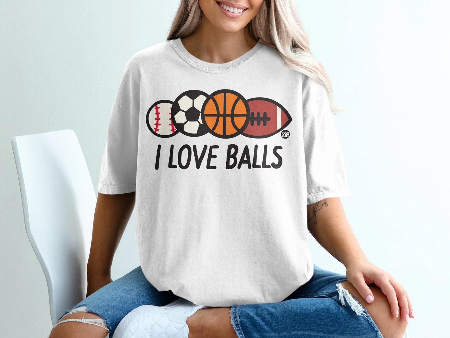 White t-shirt with "I LOVE BALLS" and various sports balls printed on it.