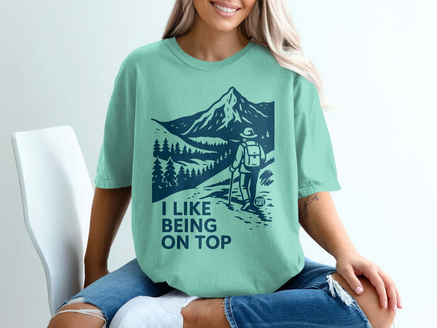 Teal t-shirt with mountain hiker graphic and text "I like being on top".