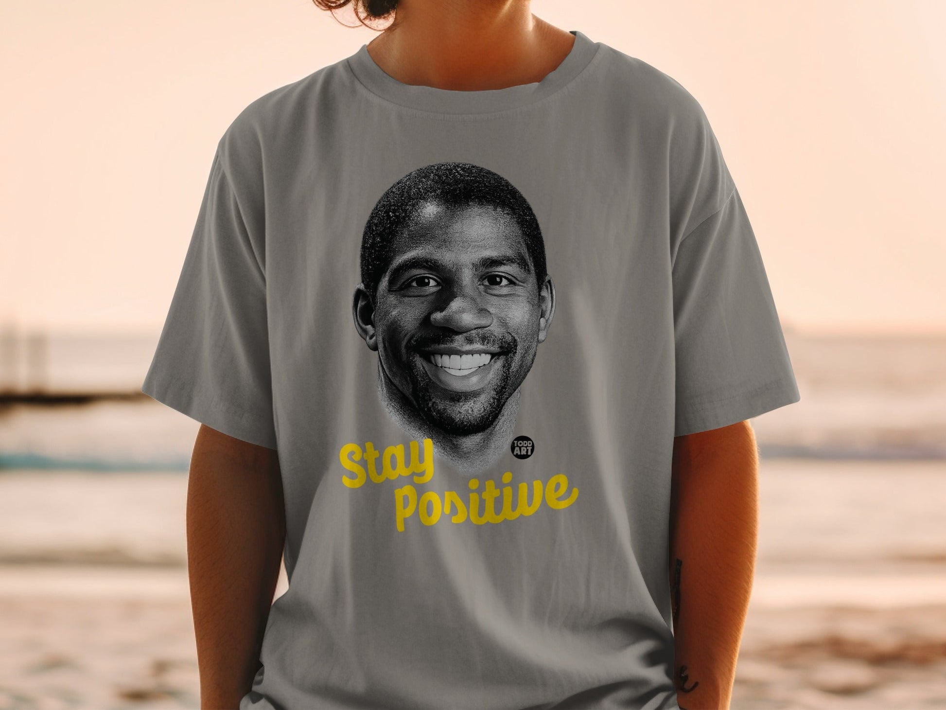 Gray t-shirt with Magic Johnson portrait and "Stay Positive" text.