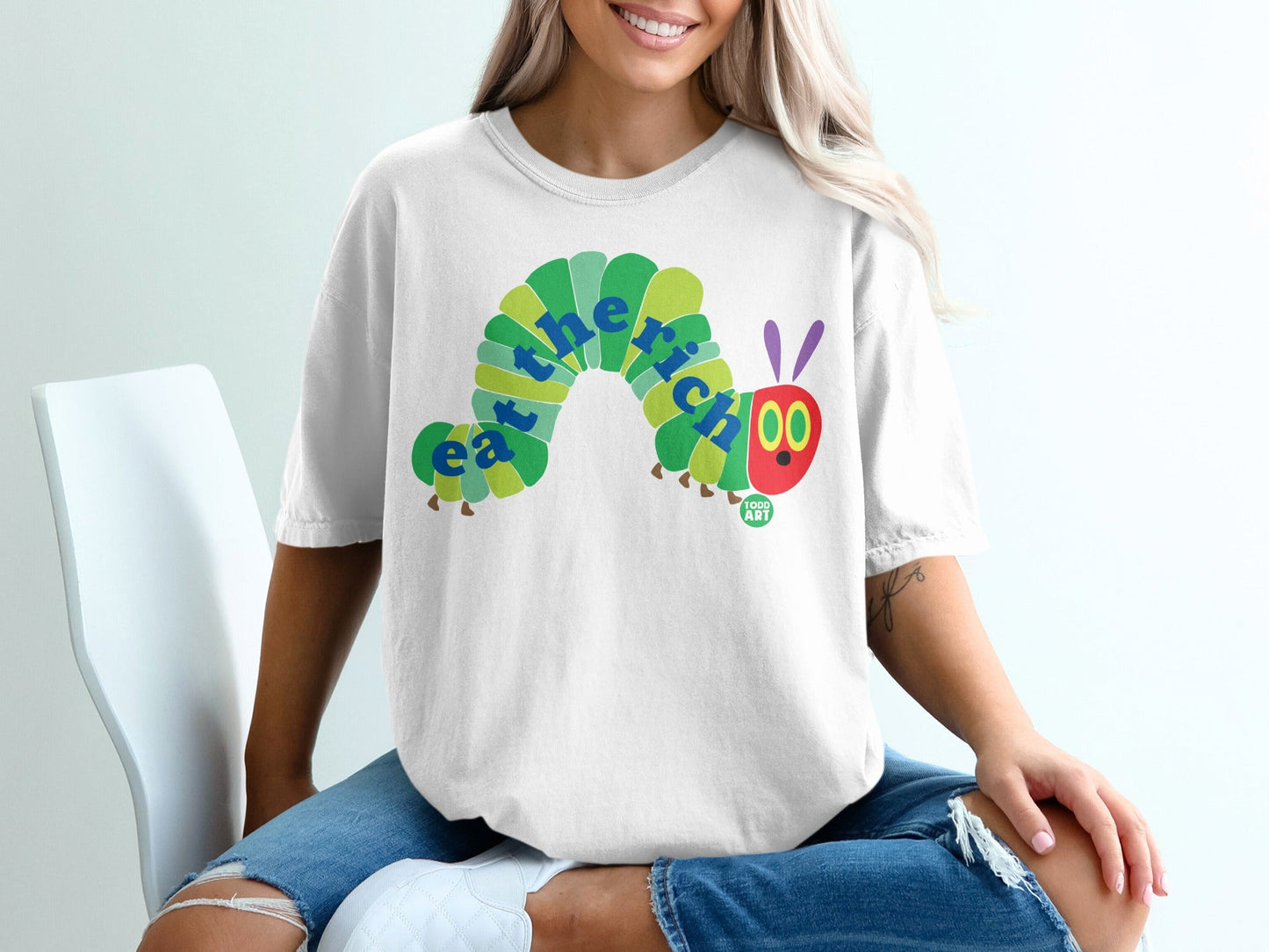 White t-shirt with "eat the rich" caterpillar design.