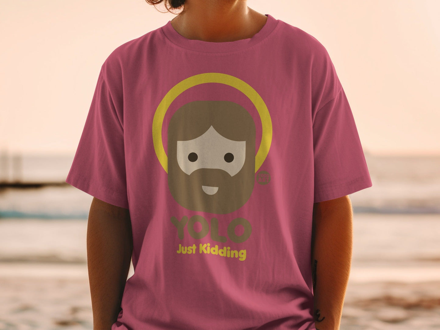 Pink t-shirt with cartoon Jesus saying "YOLO Just Kidding".