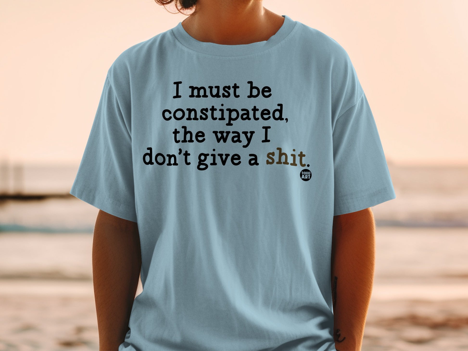 Light blue t-shirt with "I must be constipated, the way I don't give a shit" text.