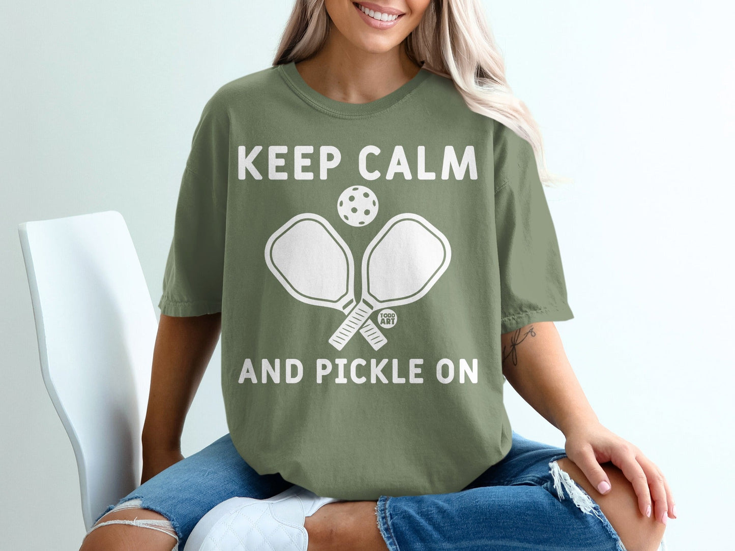 Olive green t-shirt with "Keep Calm and Pickle On" and pickleball paddles.