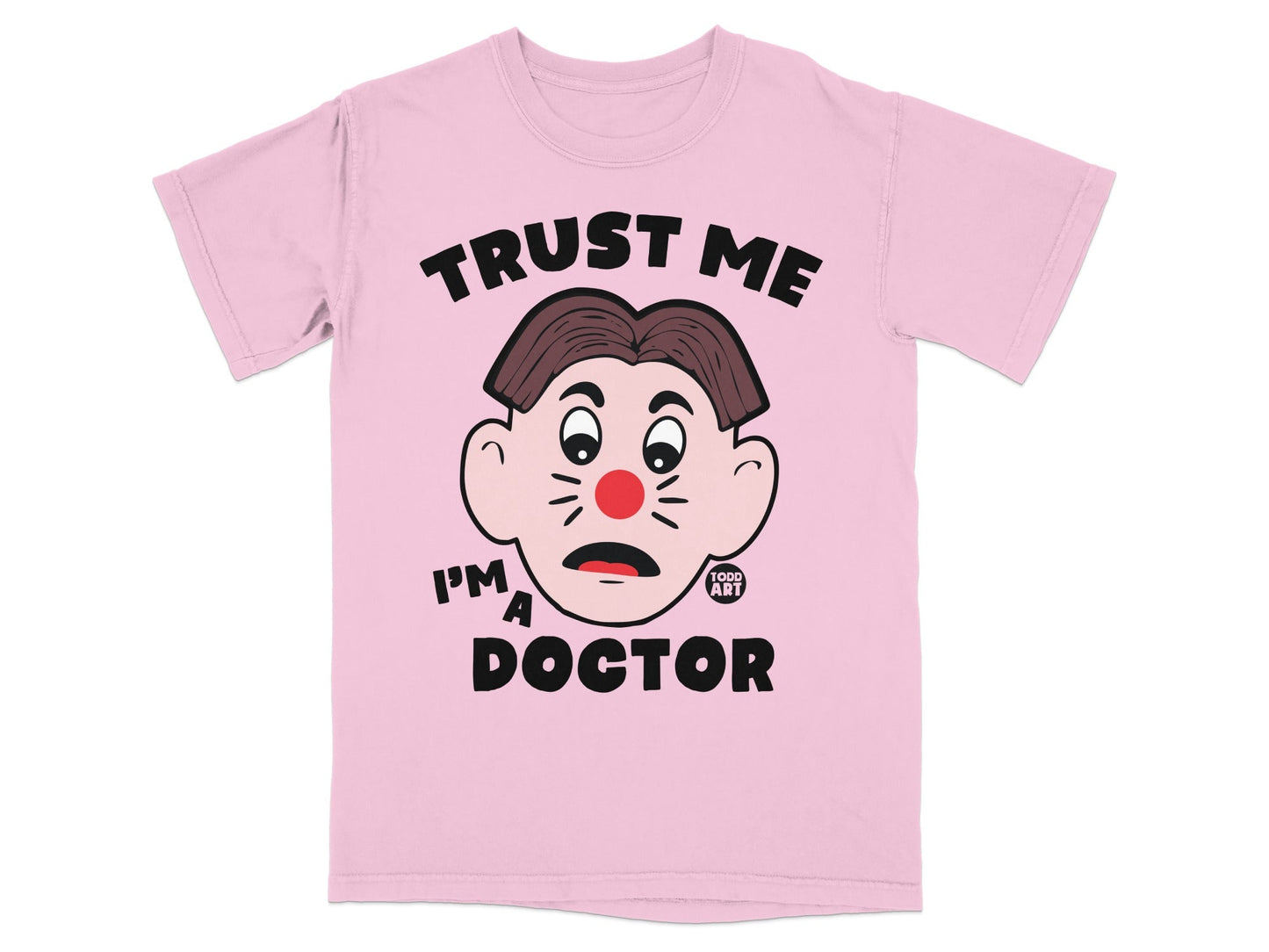 Pink t-shirt with a cartoon face and the text "TRUST ME I'M A DOCTOR".