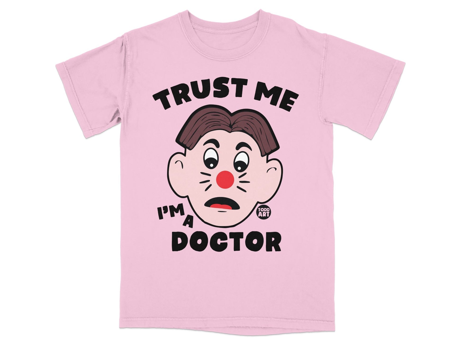 Pink t-shirt with a cartoon face and the text "TRUST ME I'M A DOCTOR".