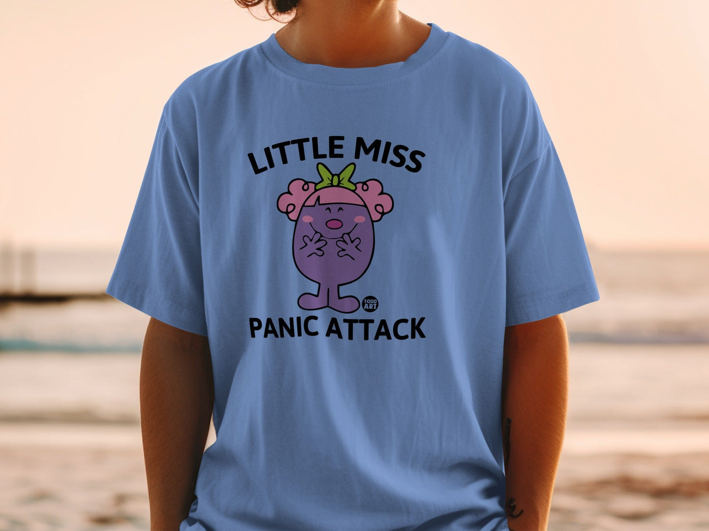 Blue t-shirt with "Little Miss Panic Attack" graphic and cartoon character.