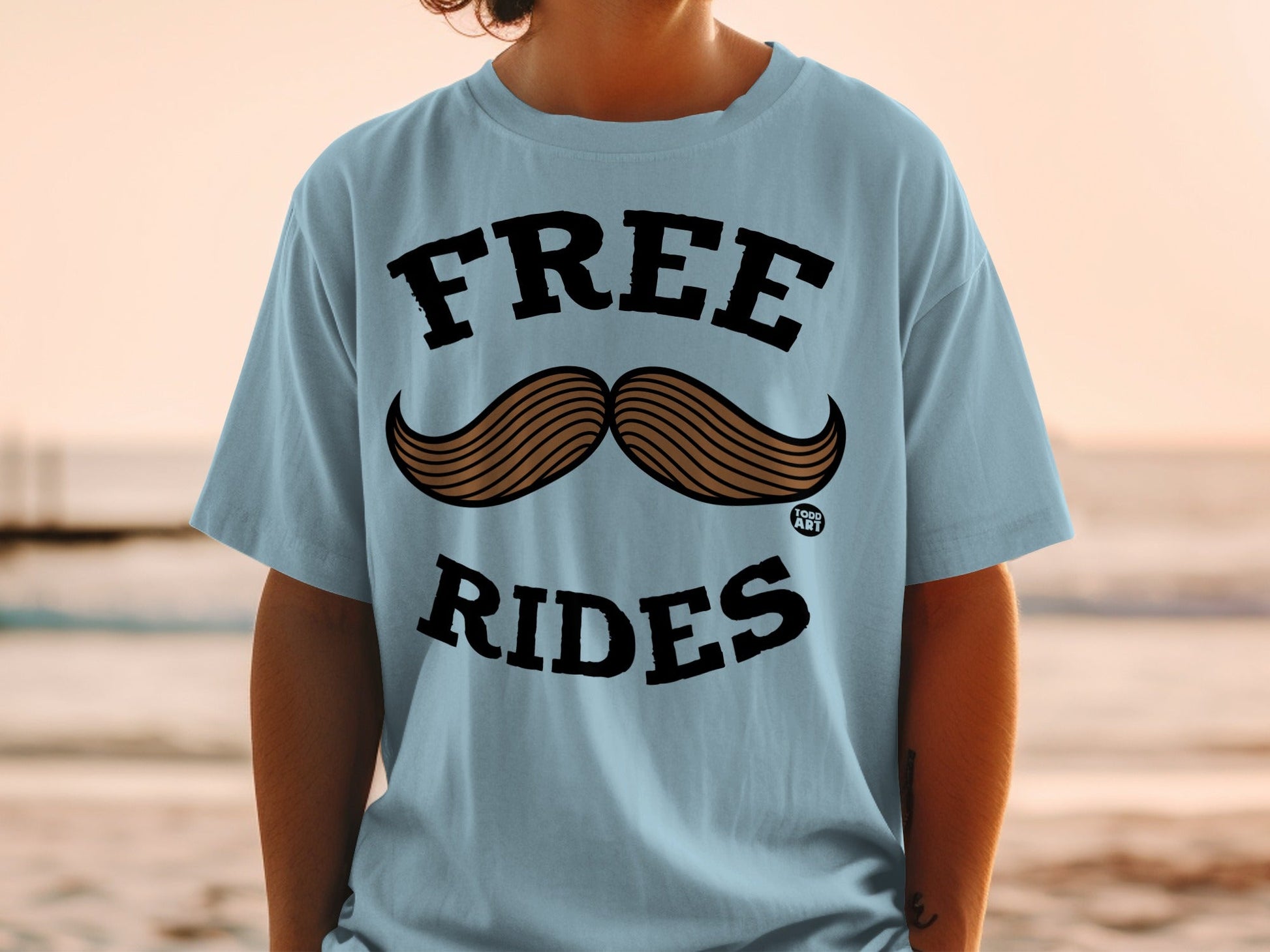 Light blue t-shirt with "FREE RIDES" and mustache graphic.