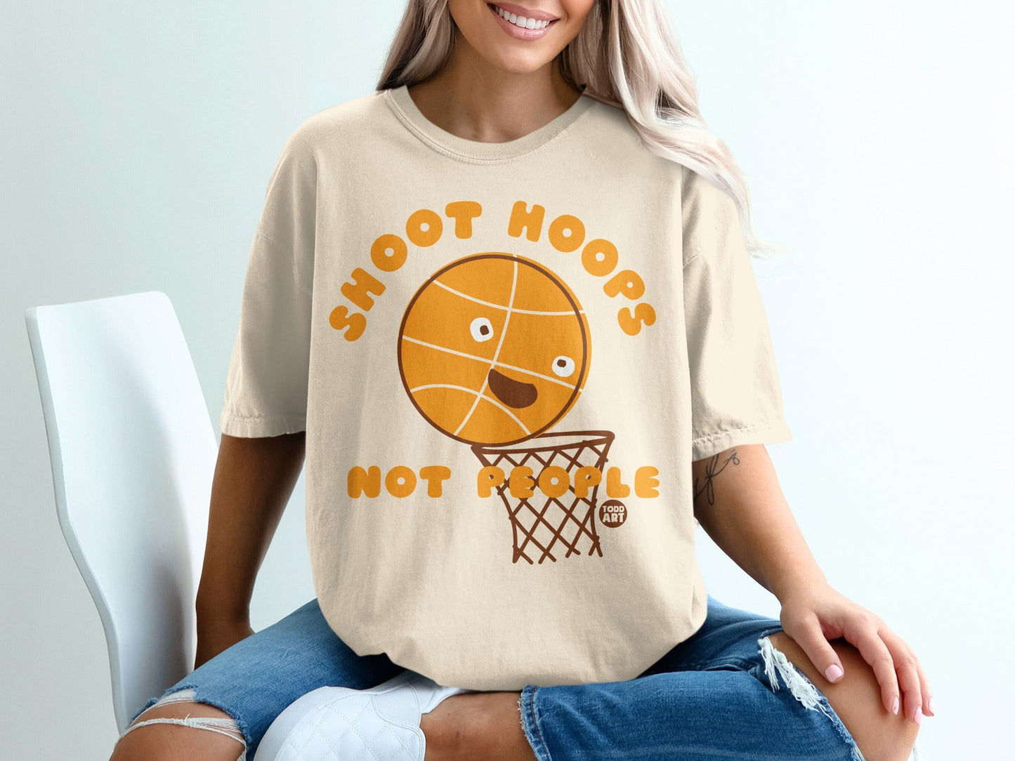 Cream t-shirt with cartoon basketball and hoop saying "SHOOT HOOPS".