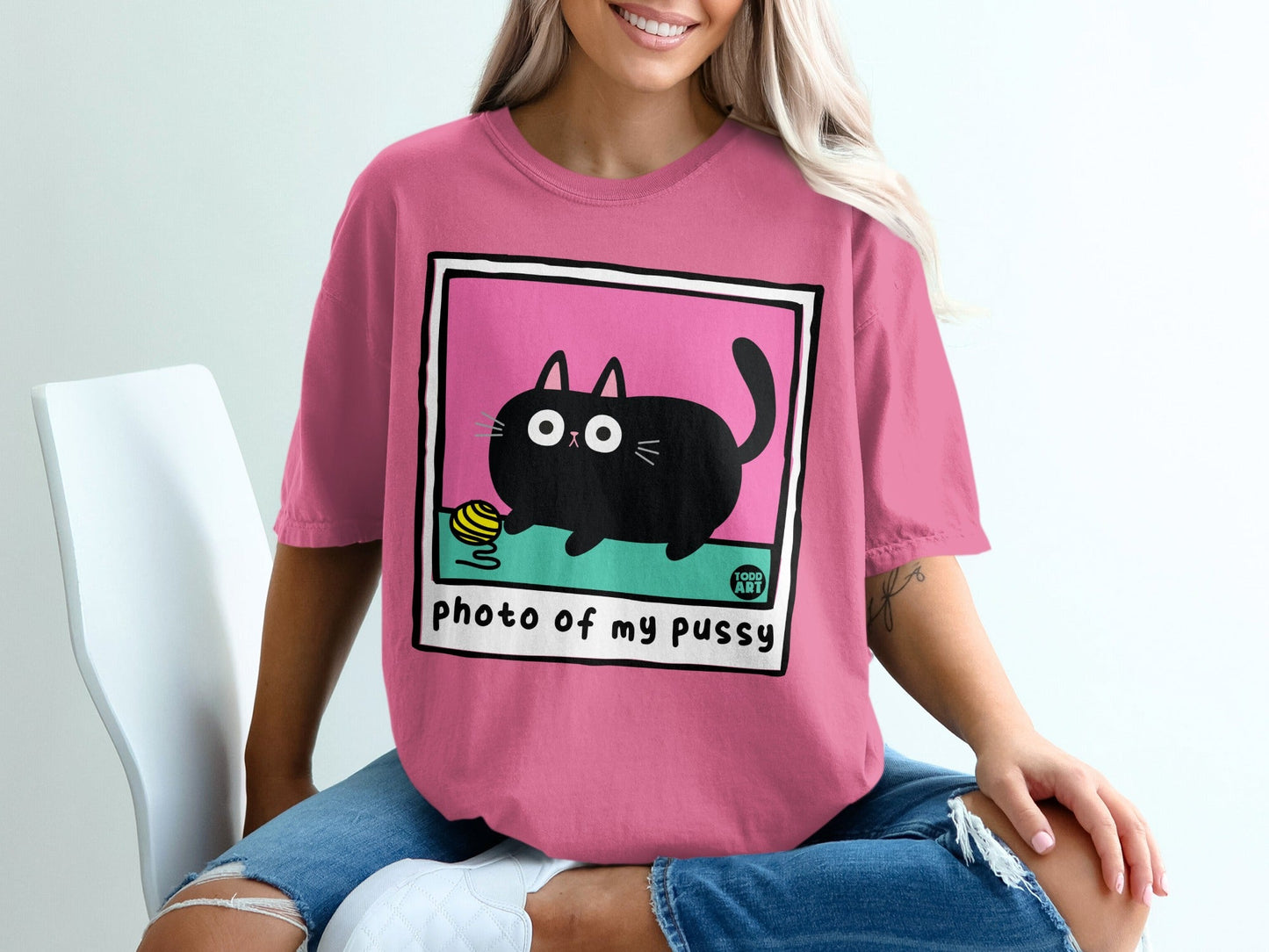 Pink t-shirt with black cat playing with yarn graphic.