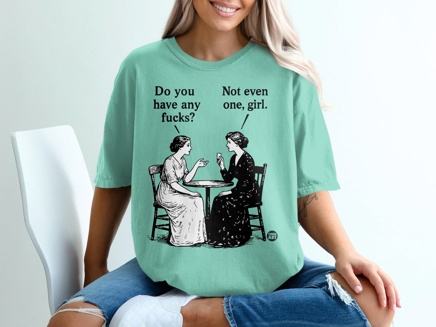 Two women at a table with text "Do you have any fucks?" and "Not even one, girl?".