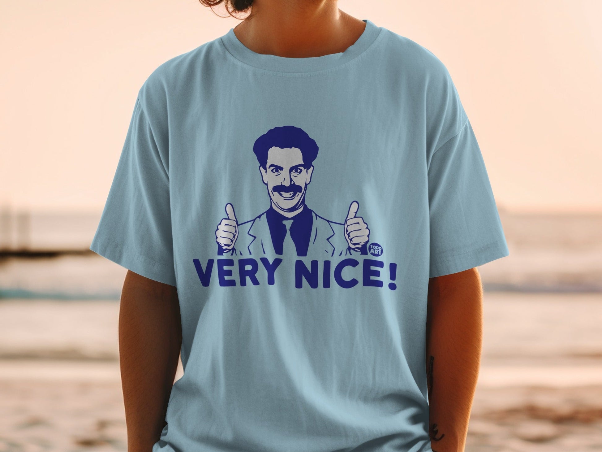 Light blue t-shirt with Borat character giving two thumbs up and "VERY NICE!" text.
