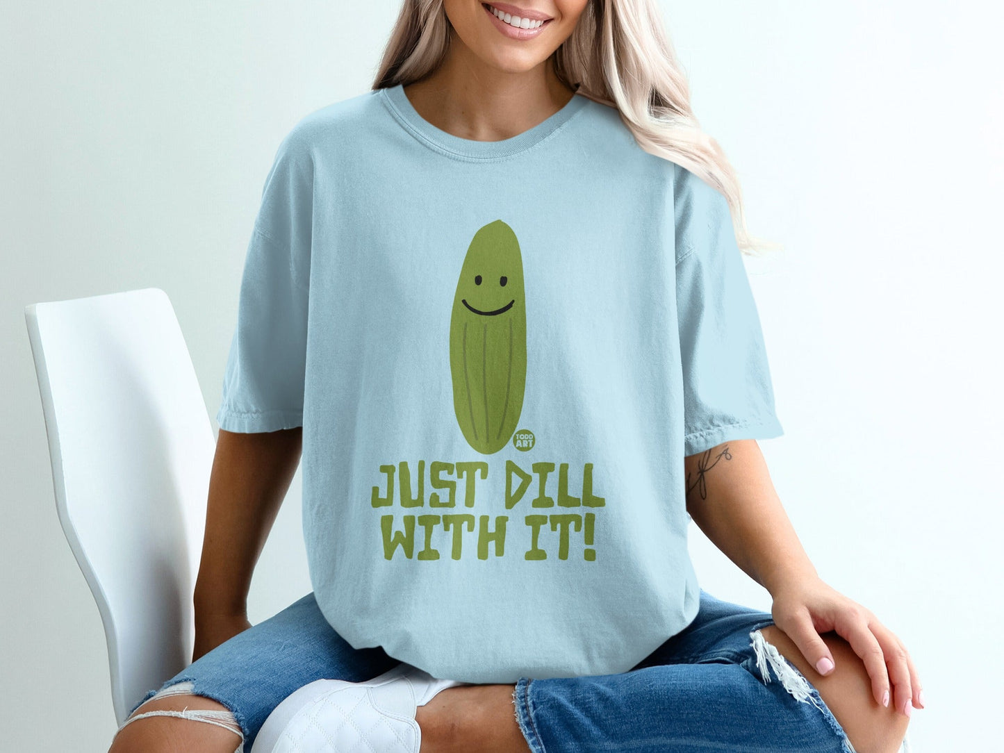 Light blue t-shirt with a smiling pickle graphic and text "JUST DILL WITH IT!".