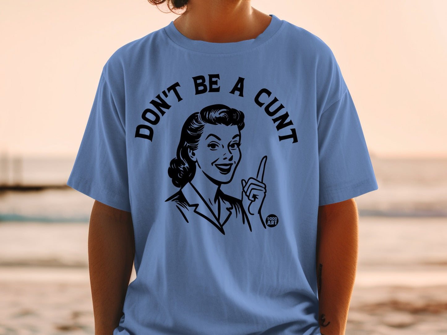 Blue t-shirt with graphic of woman pointing and text "DON'T BE A CUNT".