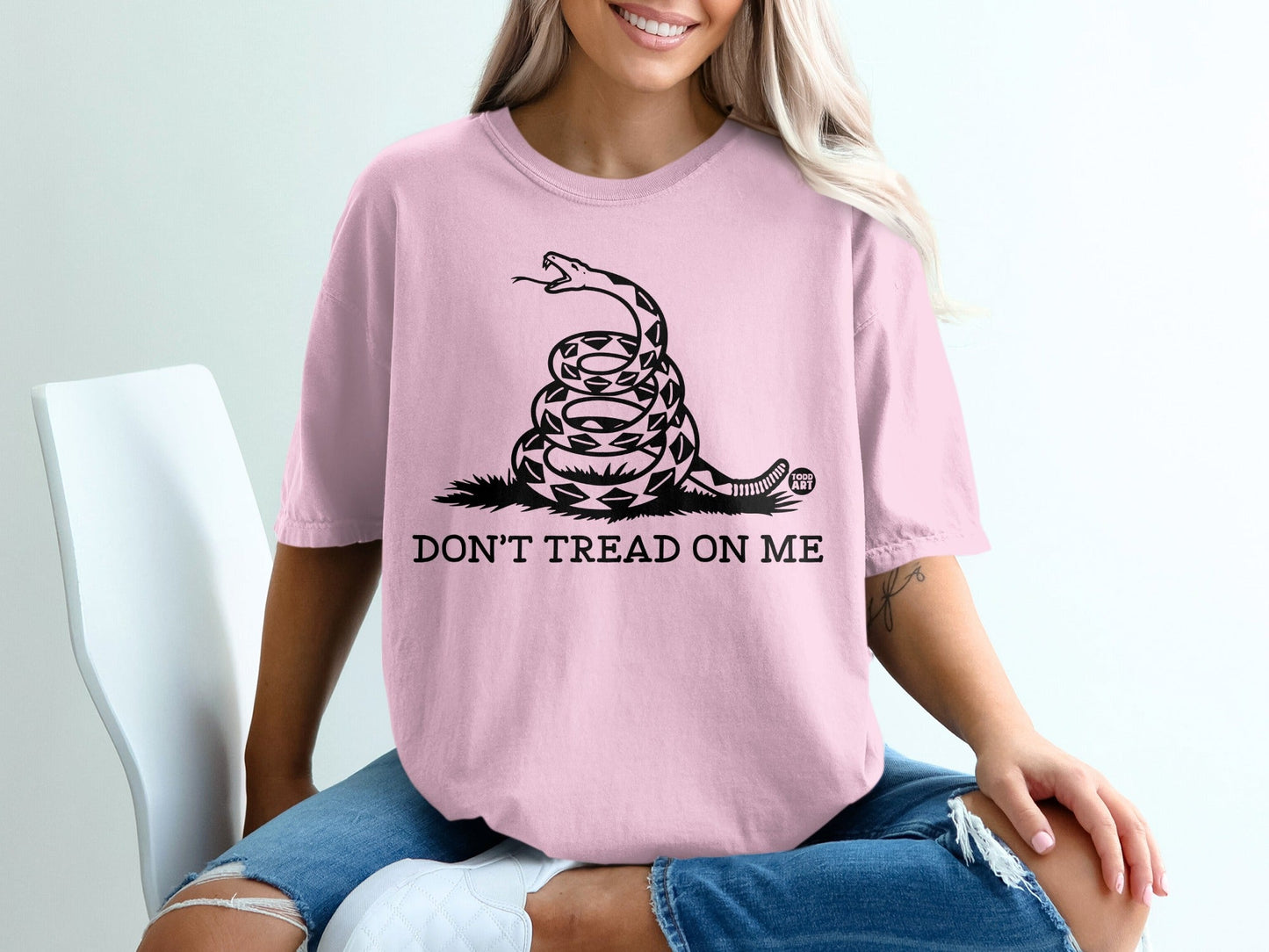 Pink t-shirt with coiled snake and "Don't Tread On Me" text.