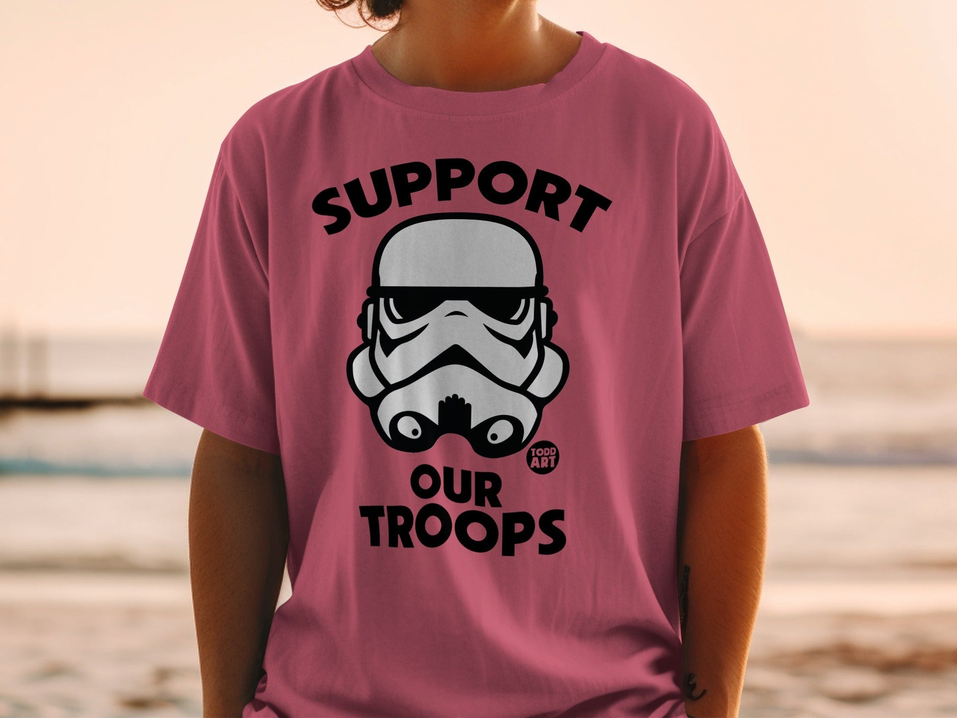 Pink t-shirt with black "Support Our Troops" text and Stormtrooper helmet graphic.