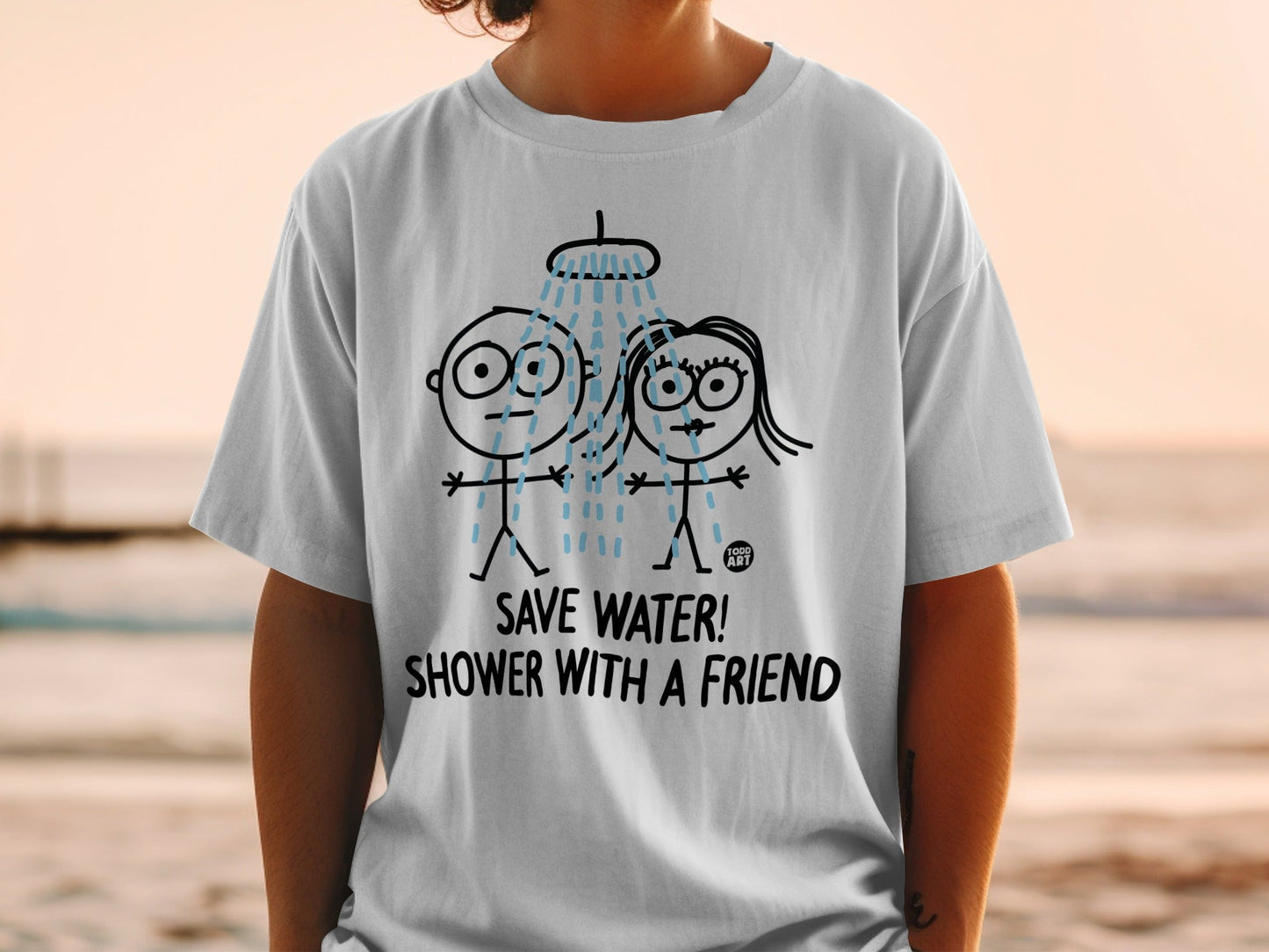 White t-shirt with cartoon couple showering, text "SAVE WATER! SHOWER WITH A FRIEND".