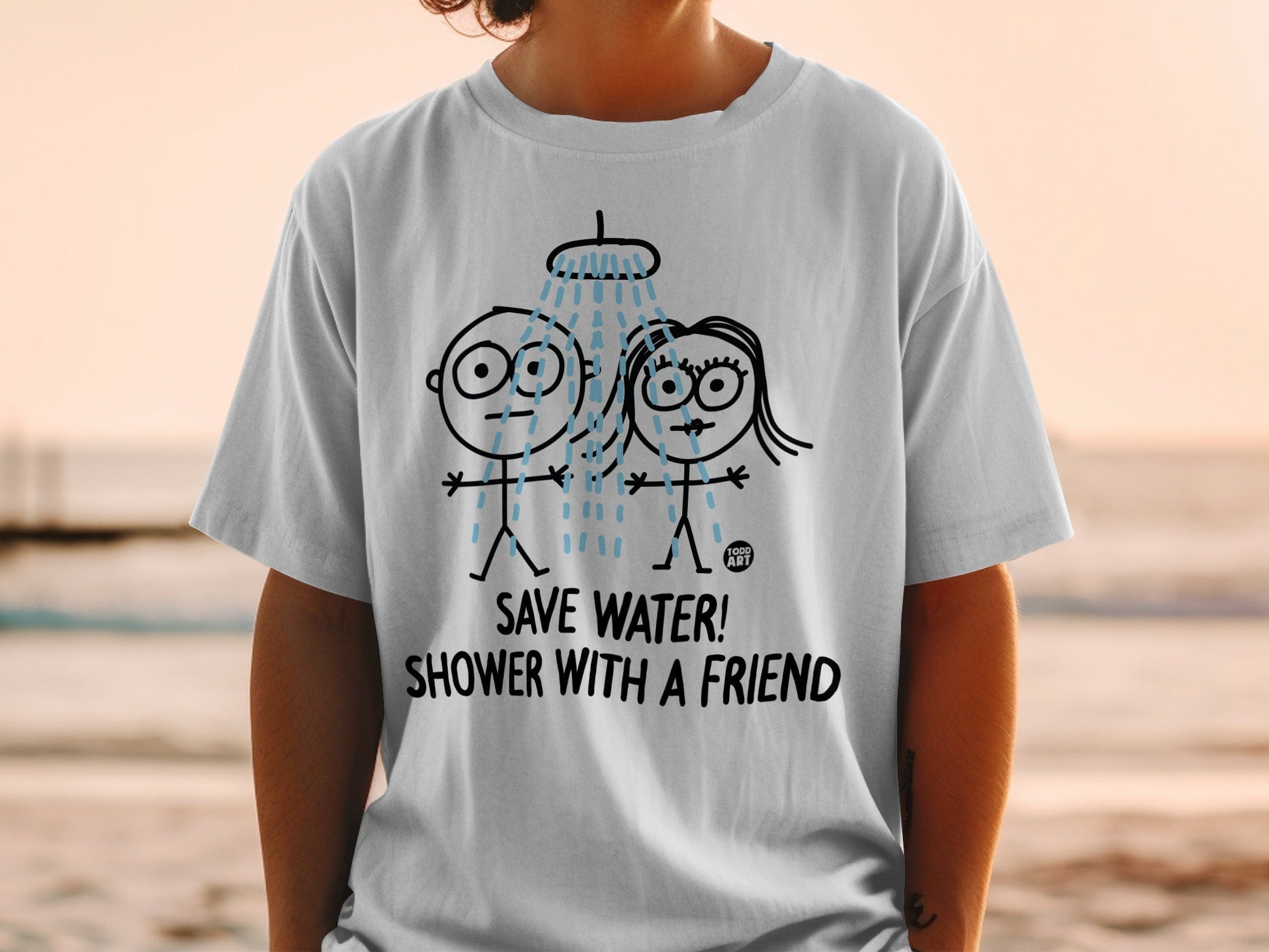 White t-shirt with cartoon couple showering, text "SAVE WATER! SHOWER WITH A FRIEND".