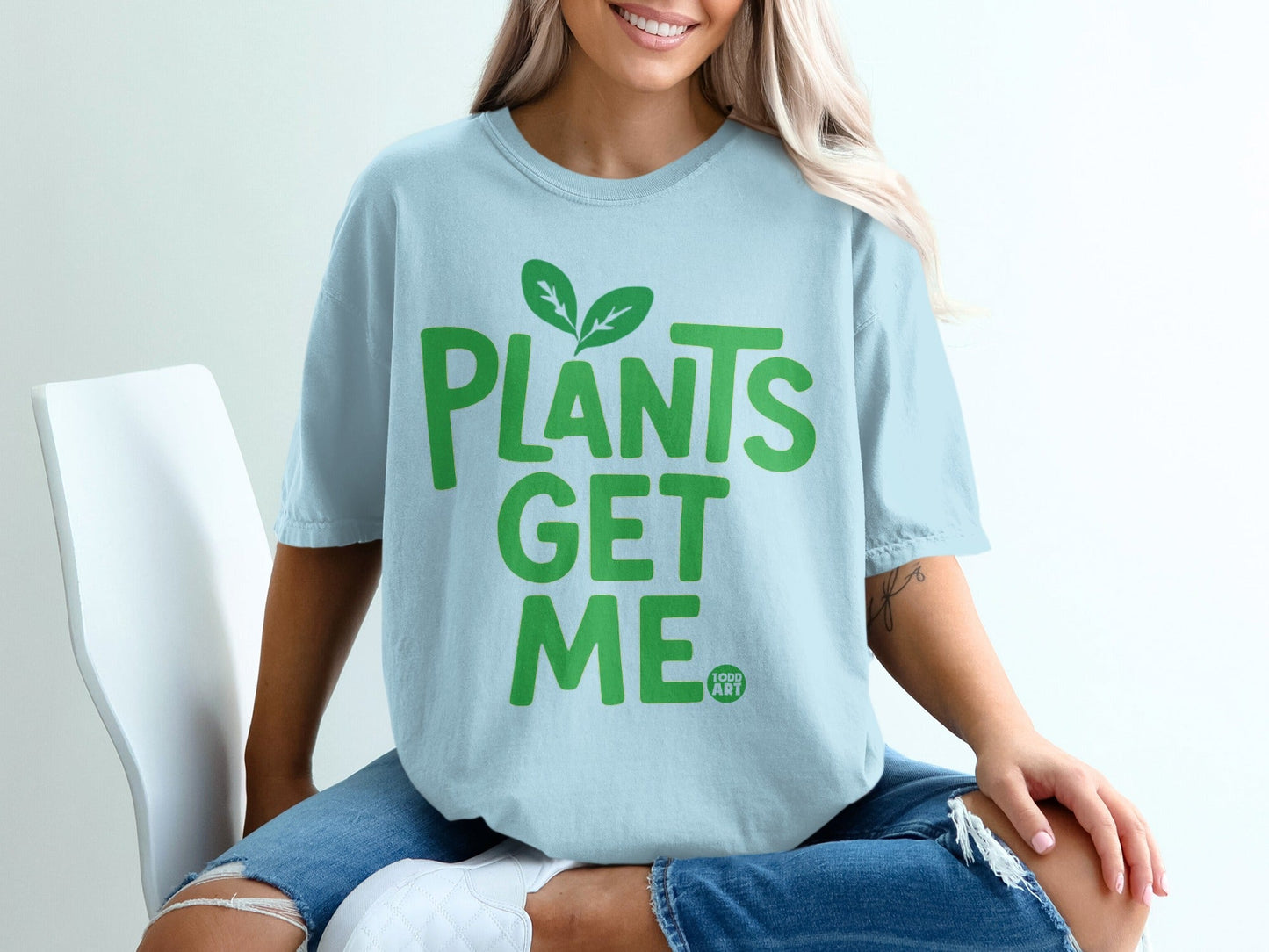 Light blue t-shirt with green text "PLANTS GET ME".