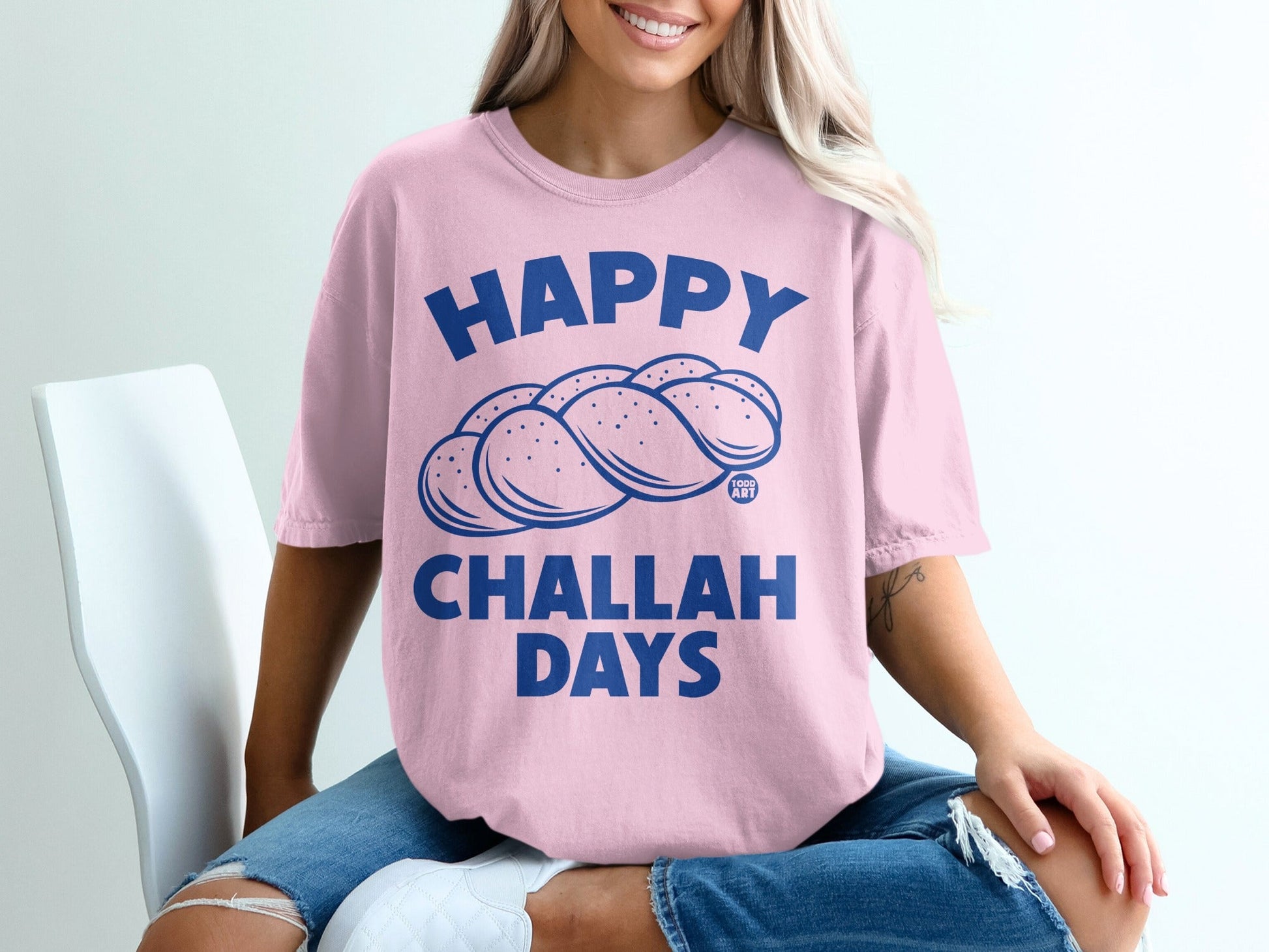Pink t-shirt with blue "Happy Challah Days" text and challah bread illustration.
