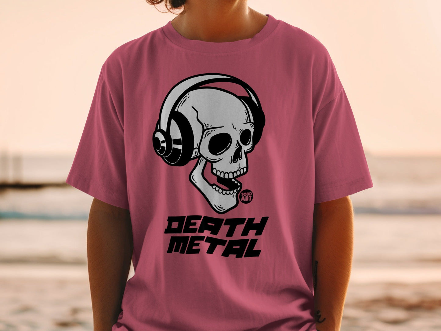Skull wearing headphones, "DEATH METAL" text, pink t-shirt.